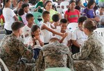 PALAWAN, Philippines (Apr. 28, 2015) - U.S. military service members talk to children during exercise Balikatan 2015's San Rafael High School ribbon cutting ceremony in San Rafael. Construction of the BK15 humanitarian civic assistance projects started this past March with the Armed Forces of the Philippines, U.S. forces and Australian forces working shoulder-to-shoulder to construct a two-classroom building for Santa Lourdes National High School, Sabang Elementary School, San Rafael High School and San Rafael Elementary School. This year marks the 31st iteration of the exercise, which is an annual Philippine-U.S. bilateral military training exercise and humanitarian civic assistance engagement. (U.S. Air Force photo by Staff Sgt. Christopher Hubenthal/Released)