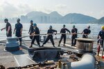 HONG KONG (Apr. 30, 2015) Sailors assigned to the Arleigh Burke-class guided-missile destroyer USS Mustin (DDG 89) haul in a line as the ship moors for a port visit. Mustin is on patrol in the U.S. 7th Fleet area of responsibility in support of security and stability in the Indo-Asia-Pacific region. 