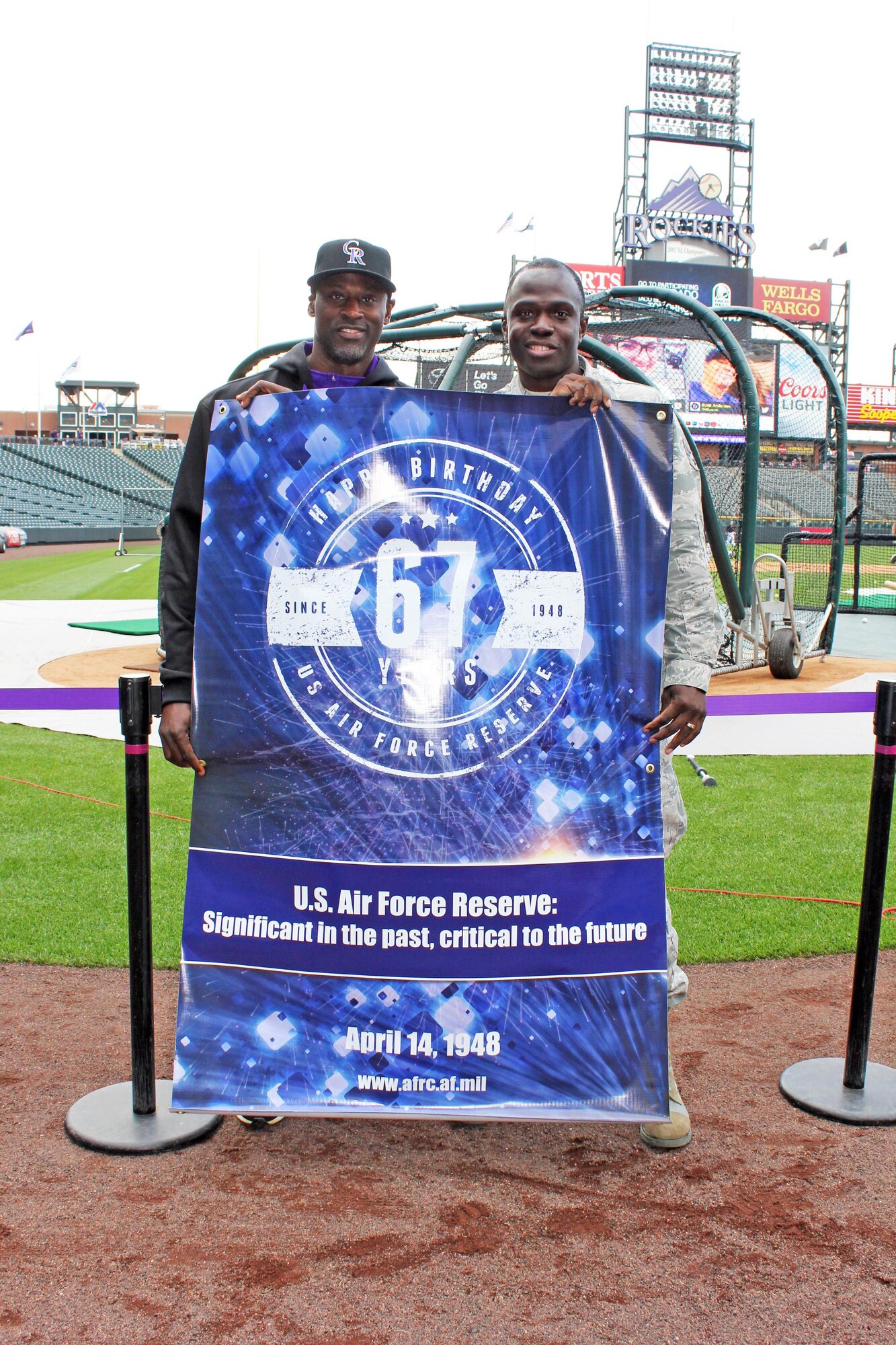 In honor of the Air Force Reserve's 67th anniversary, Air Reserve Personnel Center took photos with a comemorative banner at various events. Senior Airman Evan Joacin stands with a member of the Colorado Rockies, April 20, 2015, at Coors Field near downtown Denver. (U.S. Air Force photo/Senior Airman Evan Van Horn)