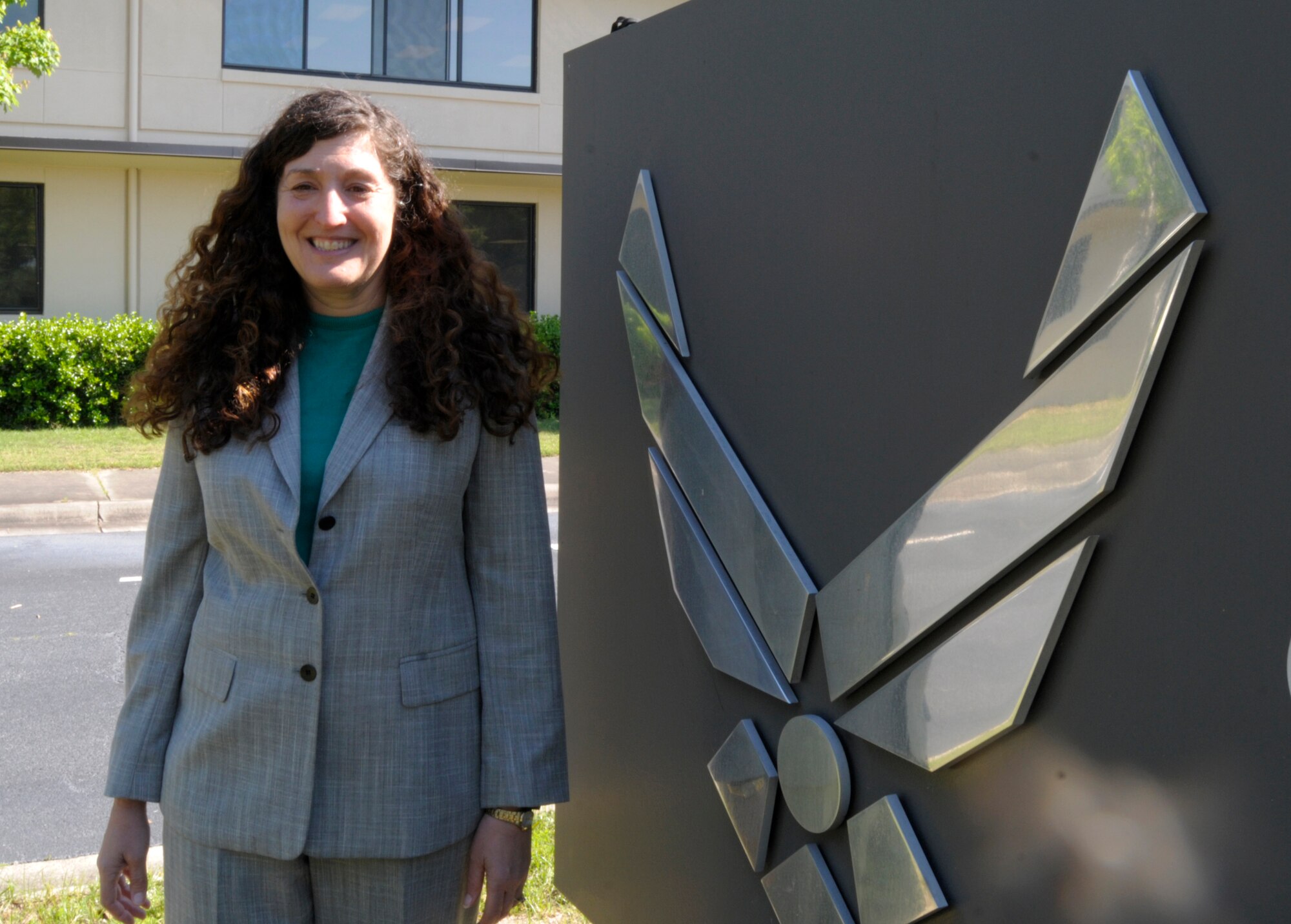 Patti Miller, Air Force Reserve Command program analyst, stands in front of the Air Force symbol on Robins Air Force Base, Ga., April 29, 2015. Miller served as a Chief Master Sgt. in the Air Force before serving as a public employee. (U.S. Air Force photo by Staff Sgt. Sarah Hanson/RELEASED)