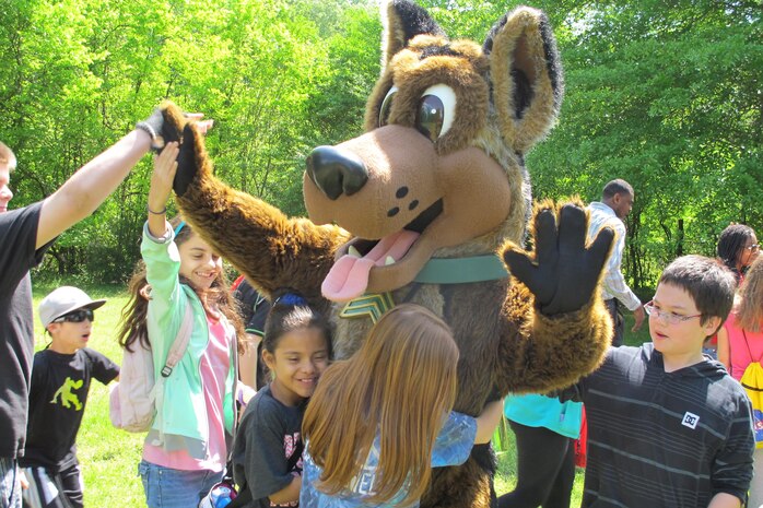 Sgt. Woof, a mascot for the Army Environmental Command, mixes and mingles with the children, emphasizing the 3Rs of unexploded ordnance safety:  Recognize, Retreat, Report.