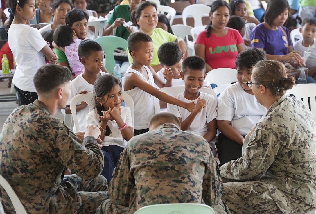 U.S. military service members talk to children during exercise Balikatan 2015’s San Rafael High School ribbon cutting ceremony, April 28, in San Rafael, Palawan, Philippines. Construction of the BK15 humanitarian civic assistance projects started this past March with the Armed Forces of the Philippines, U.S. forces and Australian forces working shoulder-to-shoulder to construct a two-classroom building for Santa Lourdes National High School, Sabang Elementary School, San Rafael High School and San Rafael Elementary School. This year marks the 31st iteration of the exercise, which is an annual Philippine-U.S. bilateral military training exercise and humanitarian civic assistance engagement.