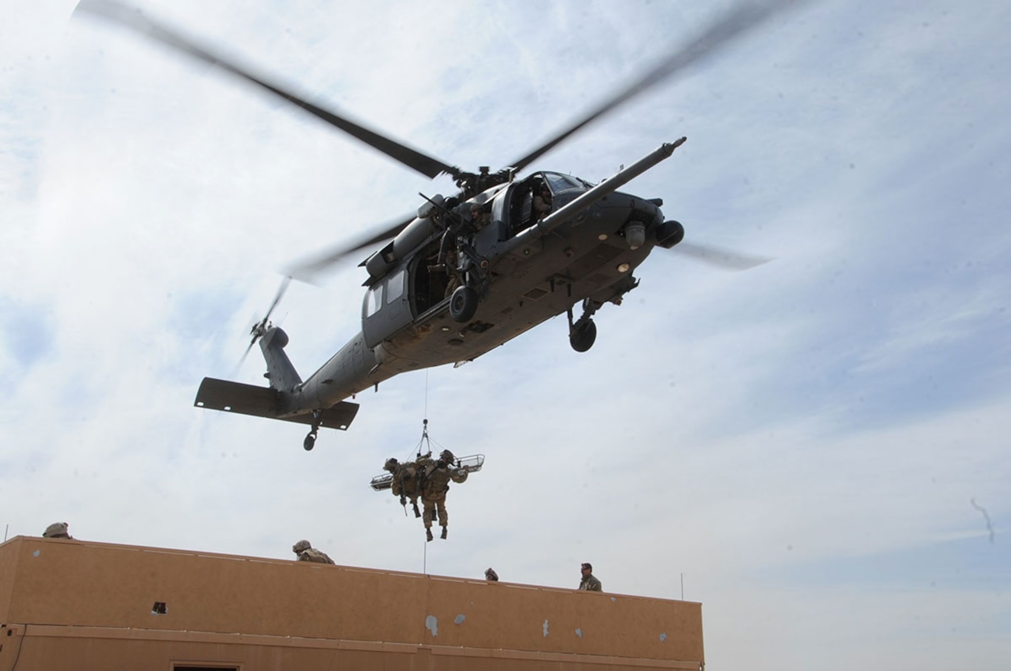 Senior Master Sgt. Doug Widener, a pararescueman with the 212th Rescue Squadron, and his teammate hoist a simulated casualty into an HH-60 Pave Hawk helicopter from the 210th Rescue Squadron during Exercise Mojave Viper at Twentynine Palms, Calif., March 2012. (U.S. Air Force photo by Staff Sgt. Cynthia Spalding)