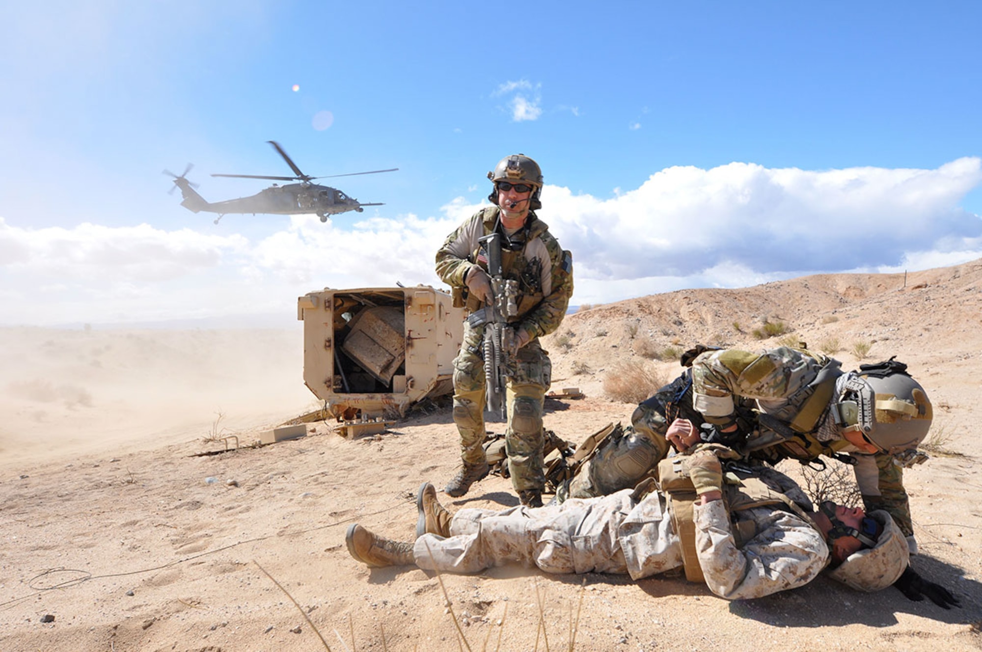 Senior Master Sgt. Doug Widener (standing), a pararescueman with the 212th Rescue Squadron, pulls security while his teammate treats a simulated casualty during Exercise Mojave Viper at Twentynine Palms, Calif., in 2012. (U.S. Air Force photo/Staff Sgt. Cynthia Spalding)