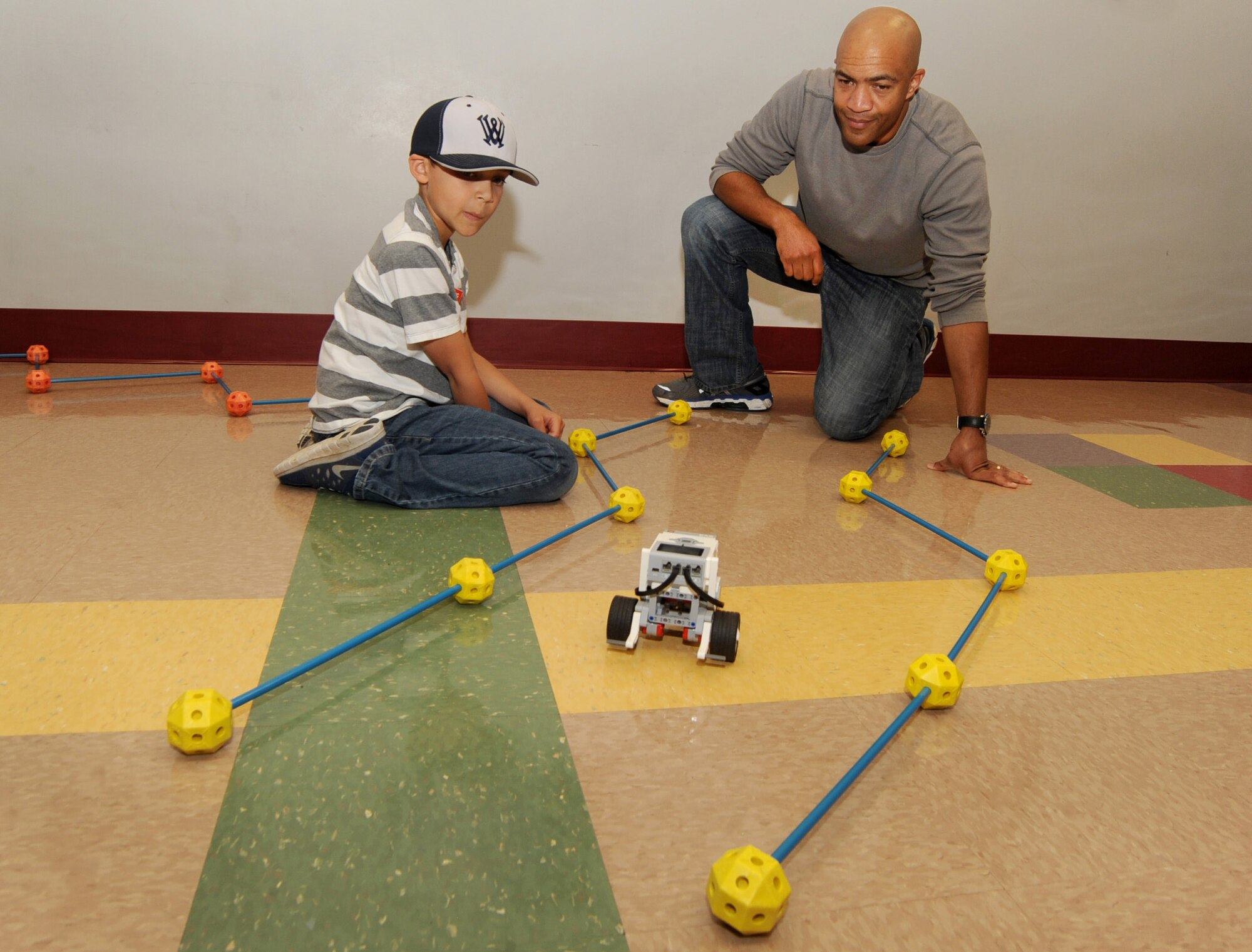 Oregon Air National Guard Senior Airman Brain Zimmerman, assigned to Joint Forces Headquarters, Salem, Ore., helps his son Trent test a robot they have programed at STARBASE, during ‘Kids Day at PANG’, April 25, 2015, Portland Air National Guard Base, Ore. The Oregon National Guard opened the Portland Air Base to children of military members for a special day of activities highlighting “The Month of the Military Child,” designated since 1986 by the Department of Defense as way to recognize the contribution and personal sacrifices children make to the military. (U.S. Air National Guard photo by Tech. Sgt. John Hughel, 142nd Fighter Wing Public Affairs/Released)