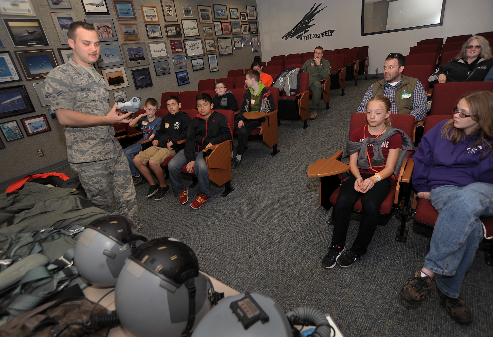 Oregon Air National Guard Airman 1st Class Joseph Stitzel, assigned to the 123rd Fighter Squadron, 142nd Fighter Wing as an aircrew flight equipment technician, left, displays and describes some of the necessary flight gear used by Air Force pilots to some of the kids that attended, ‘Kids Day at PANG,’ April 25, 2015, Portland Air National Guard Base, Ore. The Oregon National Guard opened the Portland Air Base to children of military members for a special day of activities highlighting “The Month of the Military Child,” designated since 1986 by the Department of Defense as way to recognize the contribution and personal sacrifices children make to the military. (U.S. Air National Guard photo by Tech. Sgt. John Hughel, 142nd Fighter Wing Public Affairs/Released)