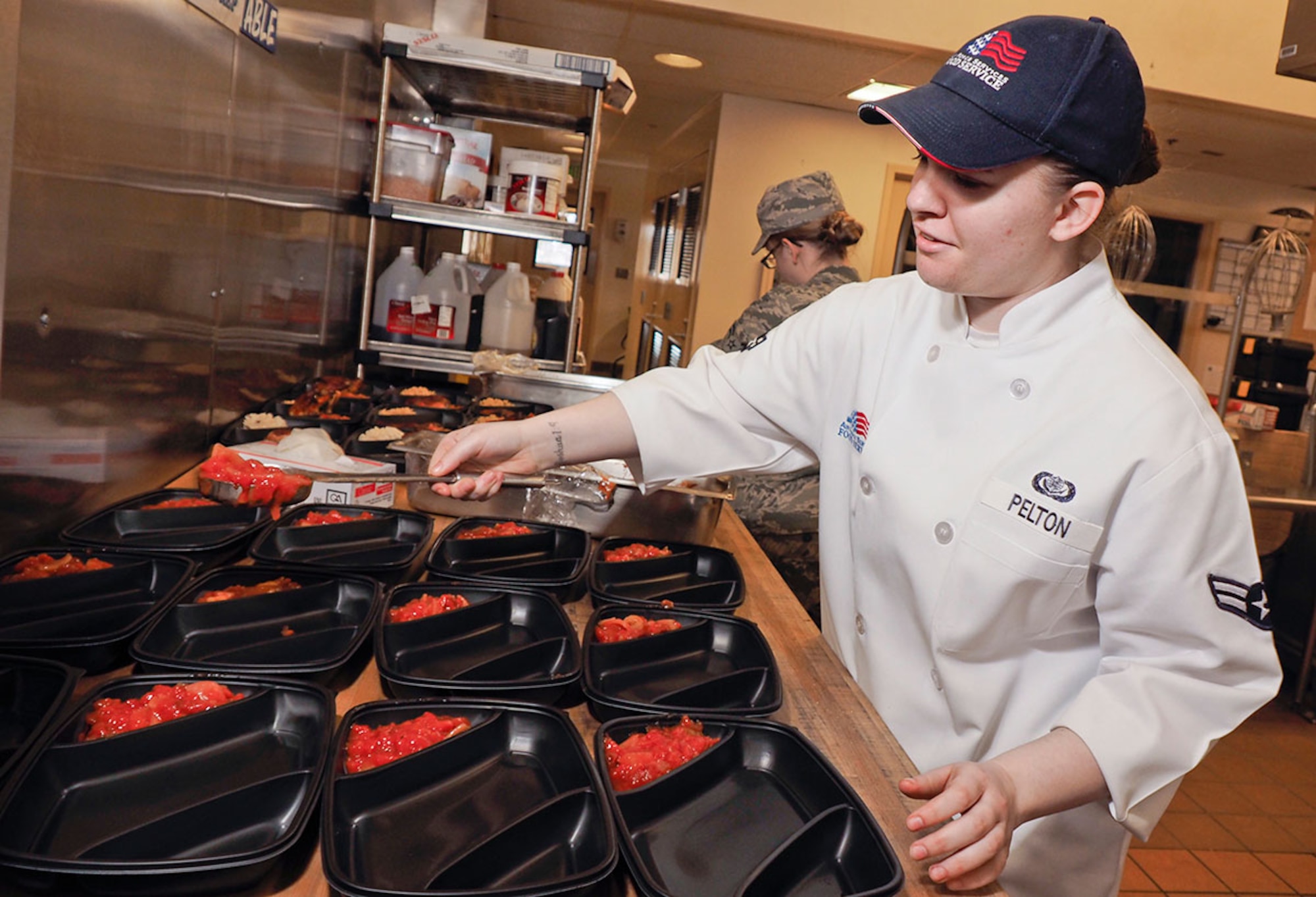Airman 1st Class Cortny Pelton, a native of Wyoming, Mich., assigned to 673d FSS, prepares food for the lunch meal at the Iditarod Dining Facility April 23. (U.S. Air Force photo/Justin Connaher)