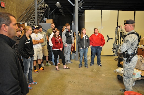 Tech. Sgt. Tyler Bassett, 114th Security Forces Squadron squad leader, shows a tactical rig to a group of high school juniors and seniors during the 2015 South Dakota Air National Guard Career Day at Joe Foss Field, S.D., April 29, 2015. The event was held to showcase the many careers the South Dakota Air National Guard has to offer to potential recruits. (National Guard photo by Staff Sgt. Luke Olson/Released) 