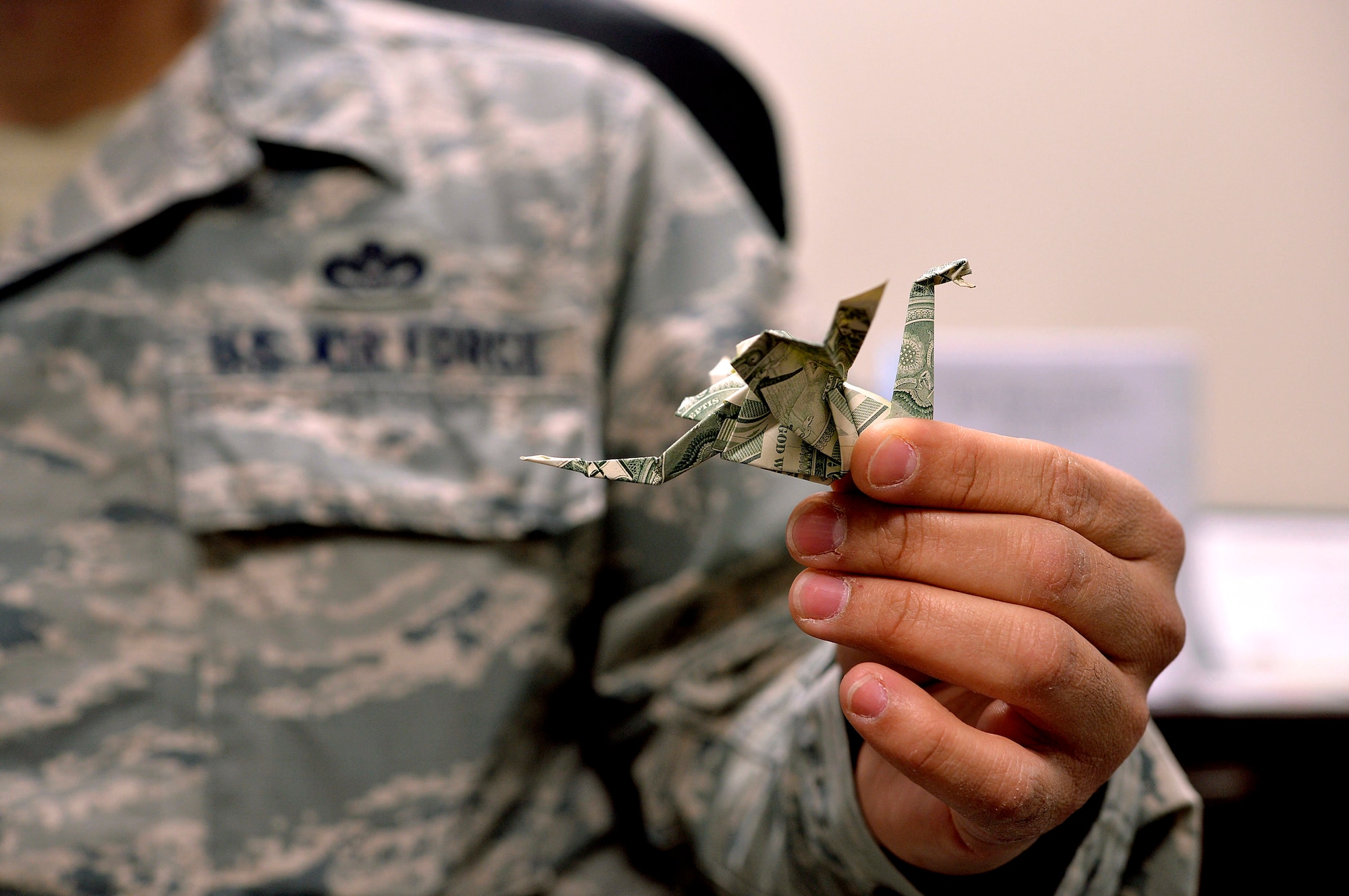 Master Sgt. Timothy Serrano, 432nd Aircraft Communications Maintenance Squadron first sergeant, holds a $3 dragon that he created on April 6, 2015 at Creech Air Force Base, Nevada. Serrano, who dedicates his spare time to creating small master pieces, learned the art of origami during middle school from various different books and online videos.  This particular origami piece is Serrano’s favorite. (U.S. Air Force photo by Senior Airman Adarius Petty/Released)