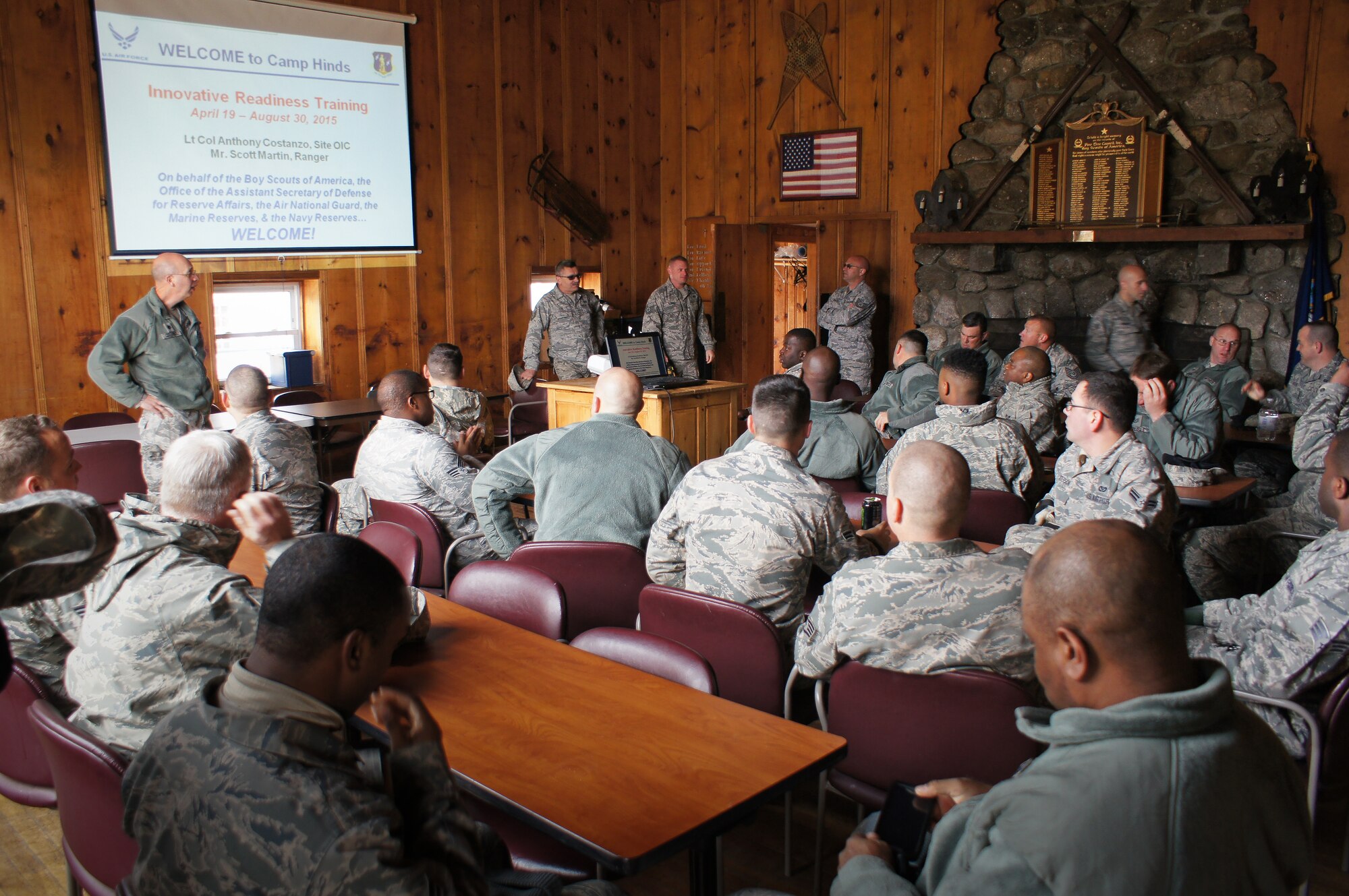U.S. Air Force civil engineers from the 116th Civil Engineer Squadron, Georgia Air National Guard, gather for a briefing after arriving at Camp William Hinds Boy Scout Camp, Raymond, Maine, April 20, 2015. The squadron, from Robins Air Force Base, Ga., spent two weeks at the camp as part of the Innovative Readiness Training program where they are the lead unit that kicked off a project to construct a new dining facility for the Boy Scout camp. The two week deployment provided the opportunity for the squadron to get real-world training similar to the way they will be deploying in the future. The Airmen set up nine tents, installed an entire electrical grid, renovated electrical, plumbing and HVAC systems on two shower shave trailers, and worked with the duration staff to ensure materials and equipment are on site to continue the mission for future rotations. (Contributed photo/Released)

