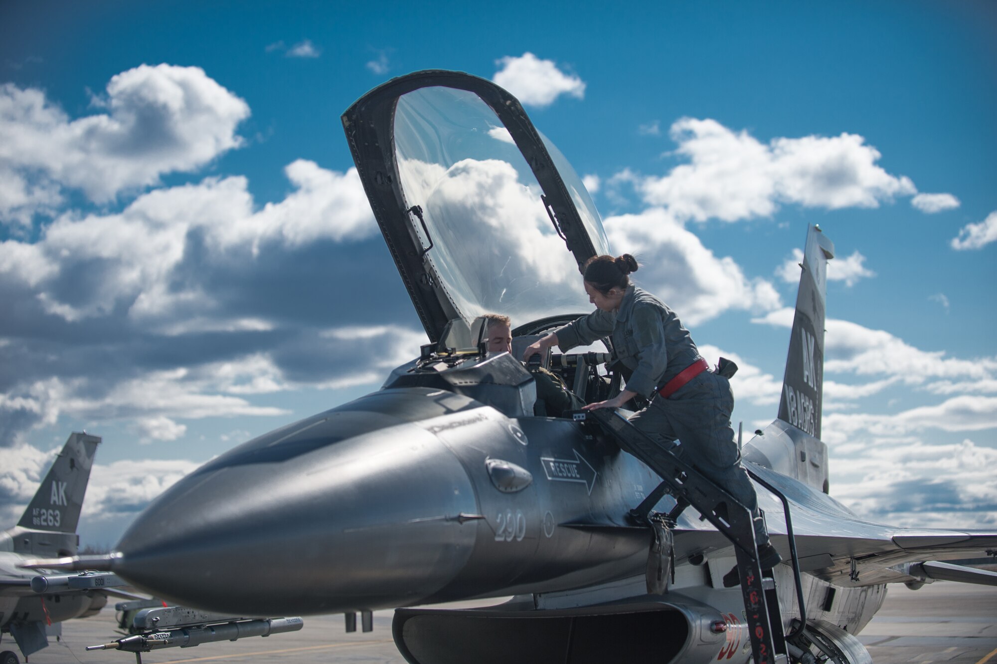 U.S. Air Force Senior Airman Michelle Park, a 354th Aircraft Maintenance Squadron assistant dedicated crew chief, assists an F-16 Fighting Falcon pilot from the 18th Aggressor Squadron prepare a jet for take off April 27, 2015, at Eielson Air Force Base, Alaska. As a crew chief, Park is a tactical aircraft maintainer who ensures her assigned jet is ready to fly at a moments notice. (U.S. Air Force photo by Staff Sgt. Shawn Nickel/Released)