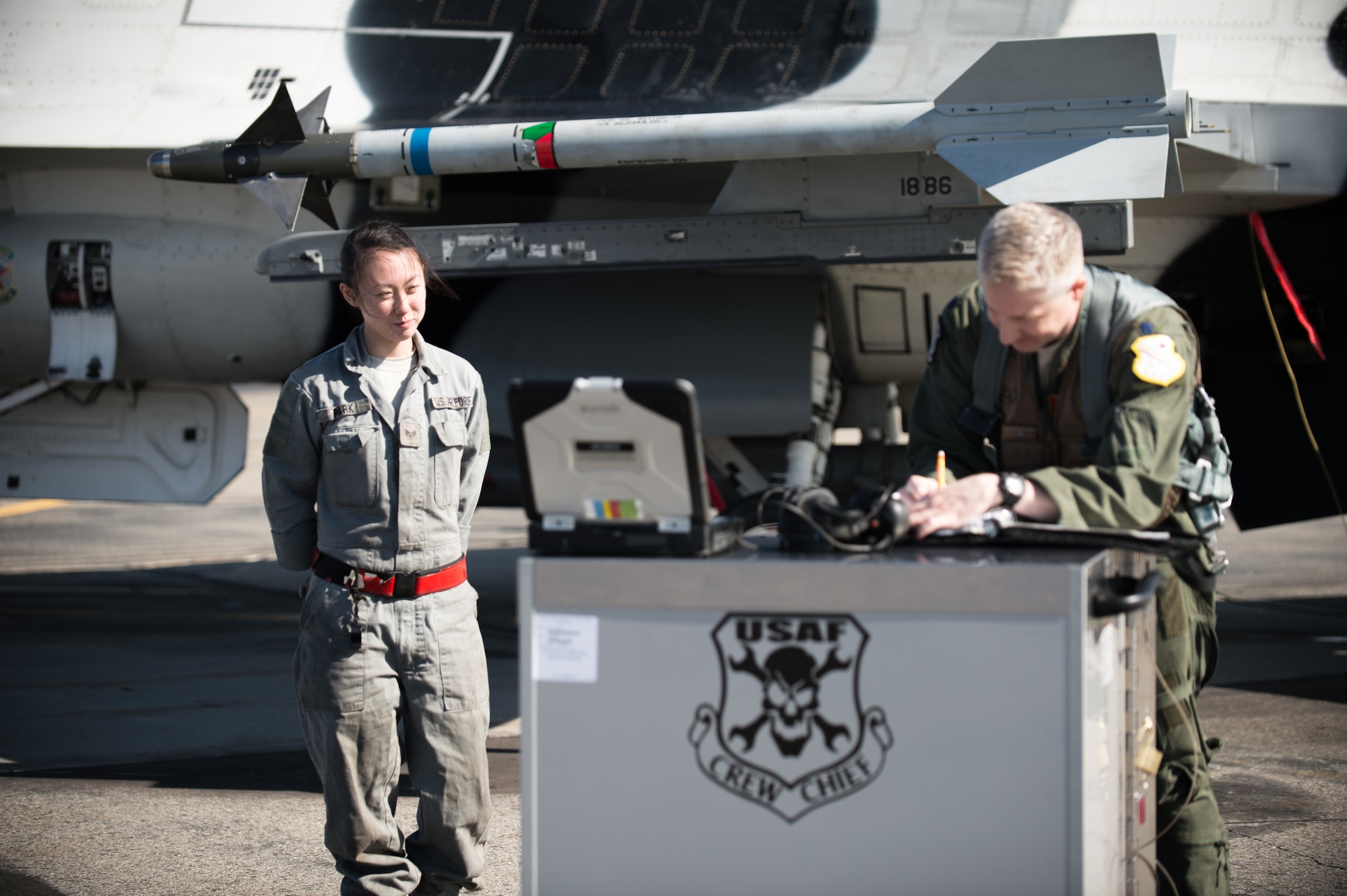 U.S. Air Force Senior Airman Michelle Park (left), a 354th Aircraft Maintenance Squadron assistant dedicated crew chief, assists an F-16 Fighting Falcon pilot from the 18th Aggressor Squadron prepare a jet for take off April 27, 2015, at Eielson Air Force Base, Alaska. As a crew chief, Park is a tactical aircraft maintainer who ensures her assigned jet is ready to fly at a moments notice. (U.S. Air Force photo by Staff Sgt. Shawn Nickel/Released)
