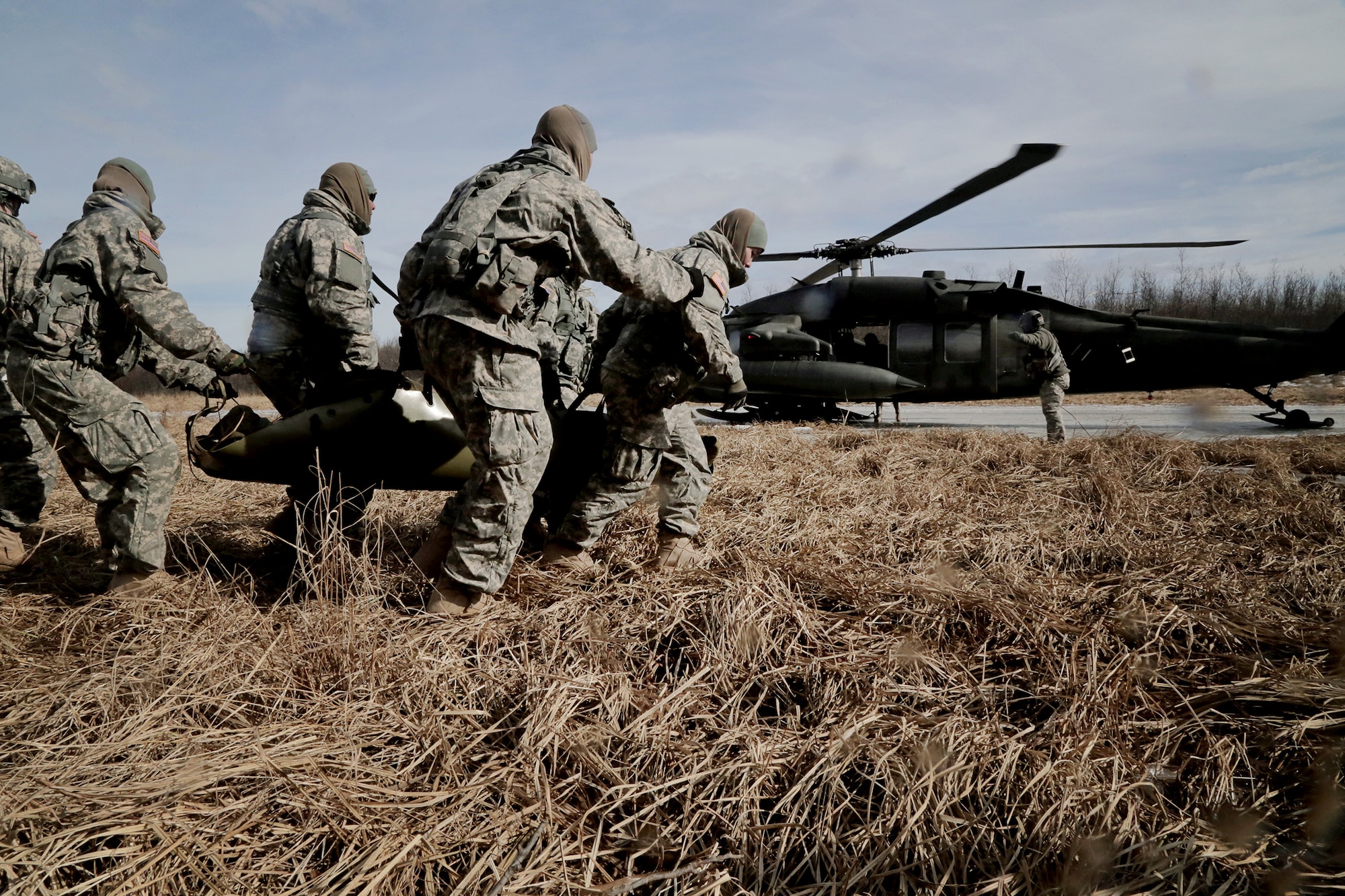 Alaska Army National Guardsmen with the 297th Battlefield Surveillance Brigade, Joint Base Elmendorf-Richardson, conduct medical evacuation field exercises with the help of a UH-60 Blackhawk helicopter during annual training near Bethel, Alaska, March 25. (U.S. Army National Guard photo by Sgt. Marisa Lindsay)