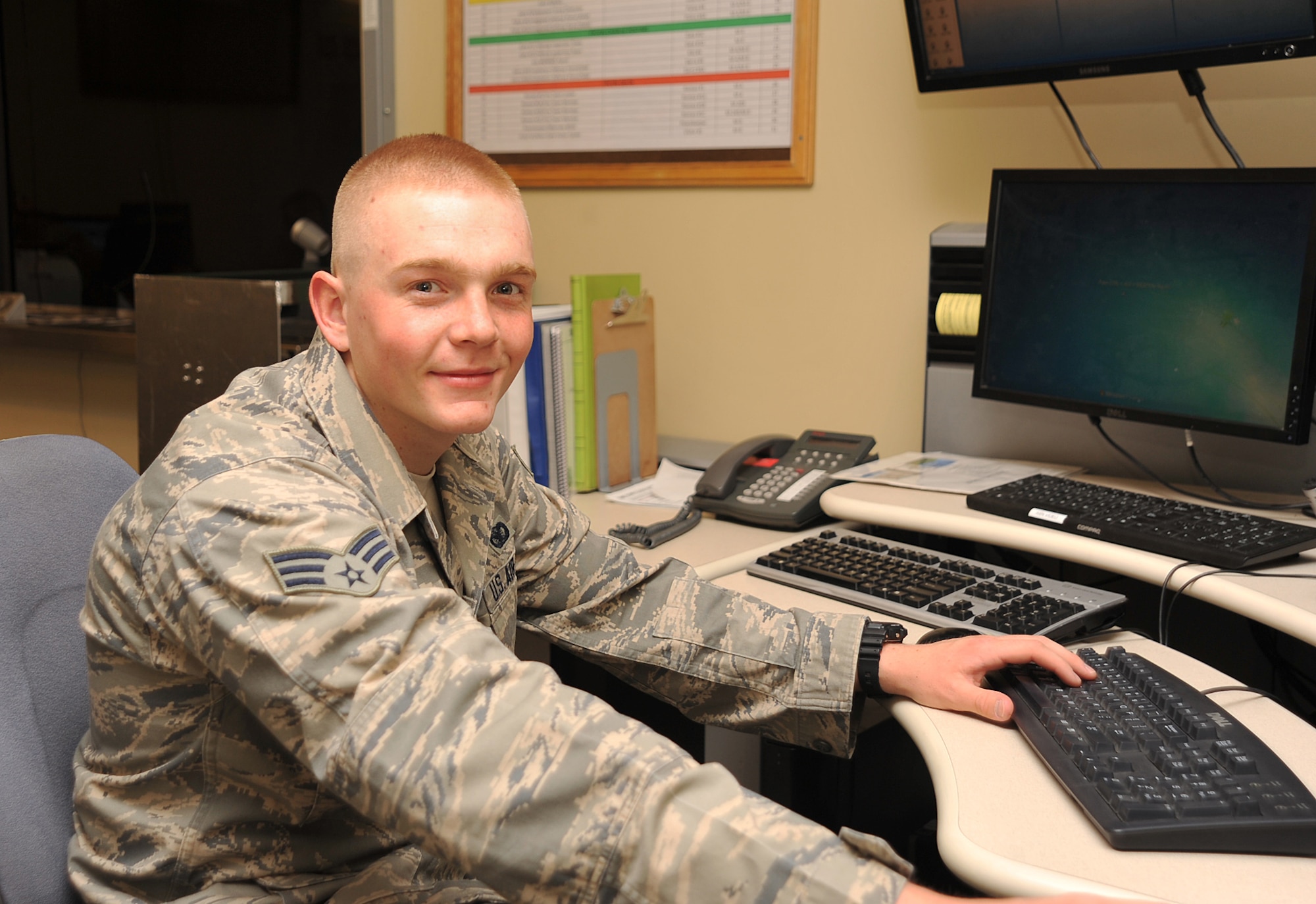 Senior Airman Sean Egan, 319th Security Forces Squadron alarm monitor, logs on to the computer to monitor live surveillance footage to detect any suspicious activity on Grand Forks Air Force Base, N.D., April 24, 2015. Egan was selected as the Warrior of the Week for the last week in April. (U.S. Air Force photo by Airman 1st Class Bonnie Grantham/Released)