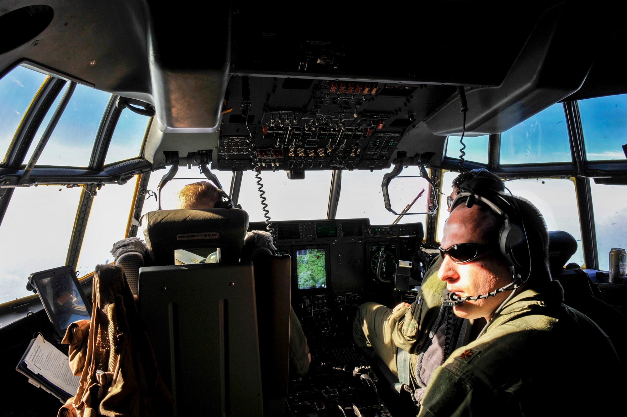 Capt. Mike Bakke and Capt. Dereck Monnier, 61st Airlift Squadron pilots, fly a C-130J while Maj. Brent Reiss, a 19th Airlift Wing director of complaints resolutions, assists the pilots in global situational awareness April 22, 2015, near Alexandria, La. The crew was flying towards Alexandria International Airport, the intermediate staging base for Green Flag Little Rock. (U.S. Air Force photo by Senior Airman Stephanie Serrano)