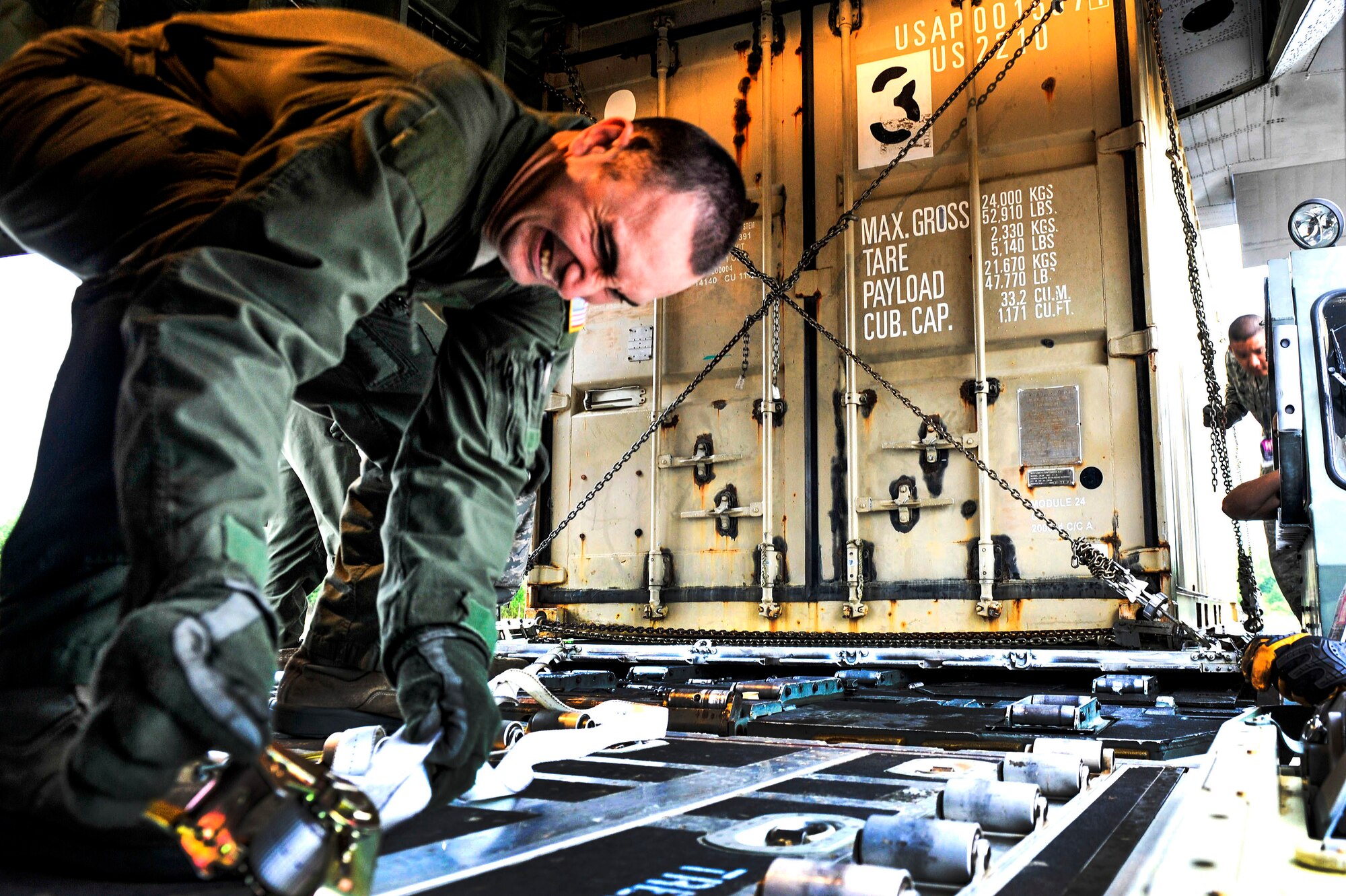 Staff Sgt. Nicholas Kaiser, a 41st Airlift Squadron loadmaster, straps down cargo in preparation for a mission April 19, 2015, at Little Rock Air Force Base, Ark.  The cargo was used in support of a Green Flag Little Rock exercise at Ft. Polk, La. (U.S. Air Force photo by Senior Airman Stephanie Serrano)