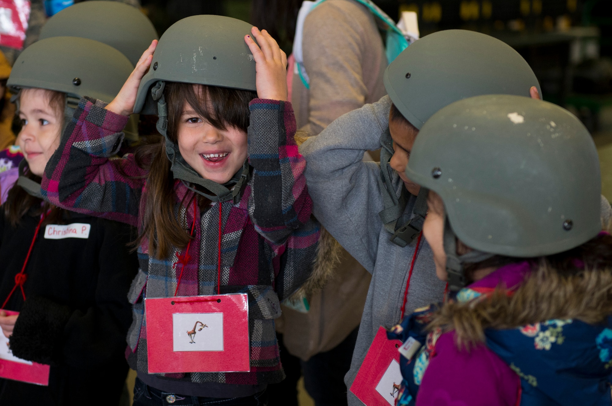 Students from Spangdahlem Elementary School try on helmets during Kids’ Deployment Day at Spangdahlem Air Base, Germany, April 29, 2015. The students also tried on body armor during their simulated deployment to Rio De Janeiro. (U.S. Air Force photo by Airman 1st Class Luke Kitterman/Released)