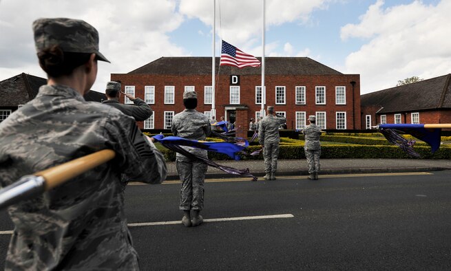 Team Mildenhall Airmen and local community leaders pay respect to the U.S. flag and Royal Air Force ensign during a retreat ceremony for Honorary Commanders’ Day April 28, 2015, on RAF Mildenhall, England. Local community leaders joined the formation to experience the retreat ceremony and to wrap up the day’s events. (U.S. Air Force photo by Airman 1st Class Kyla Gifford/Released)