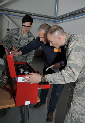 U.S. Air Force Senior Airman Keefer Patterson, left, 100th Maintenance Squadron Aerospace Maintenance journeyman from West Columbia, Texas, keeps track of time as Brian Keane, middle, Cameron Group managing director and the 100th Civil Engineer honorary commander, and U.S. Air Force Lt. Col. Kevin Parker, right, 100th CES commander, participate in a challenge during Honorary Commanders’ Day April 28, 2015, on RAF Mildenhall, England. RAF Mildenhall hosted “The Team Mildenhall Experience” for its honorary commanders to work alongside their military counterparts. (U.S. Air Force photo by Airman 1st Class Kyla Gifford/Released)