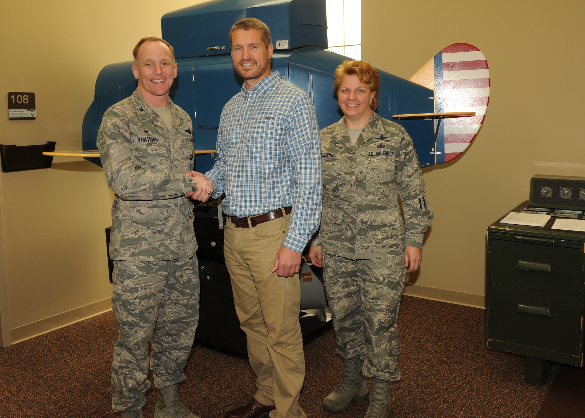 Col. Patrick Rhatigan, 19th Airlift Wing commander, along with Chief Master Sgt. Rhonda Buening, 19th Airlift Wing command chief, congratulate Kelly Kendall, an Air Mobility Command Air Operations Squadron, Detachment 3, equipment specialist, for his selection as Combat Airlifter of the Week April 27, 2015, at Little Rock Air Force Base, Ark. In two months, Kendall manned acceptance teams on two multi-million dollar training device modifications. (U.S. Air Force photo by Airman 1st Class Scott Poe)