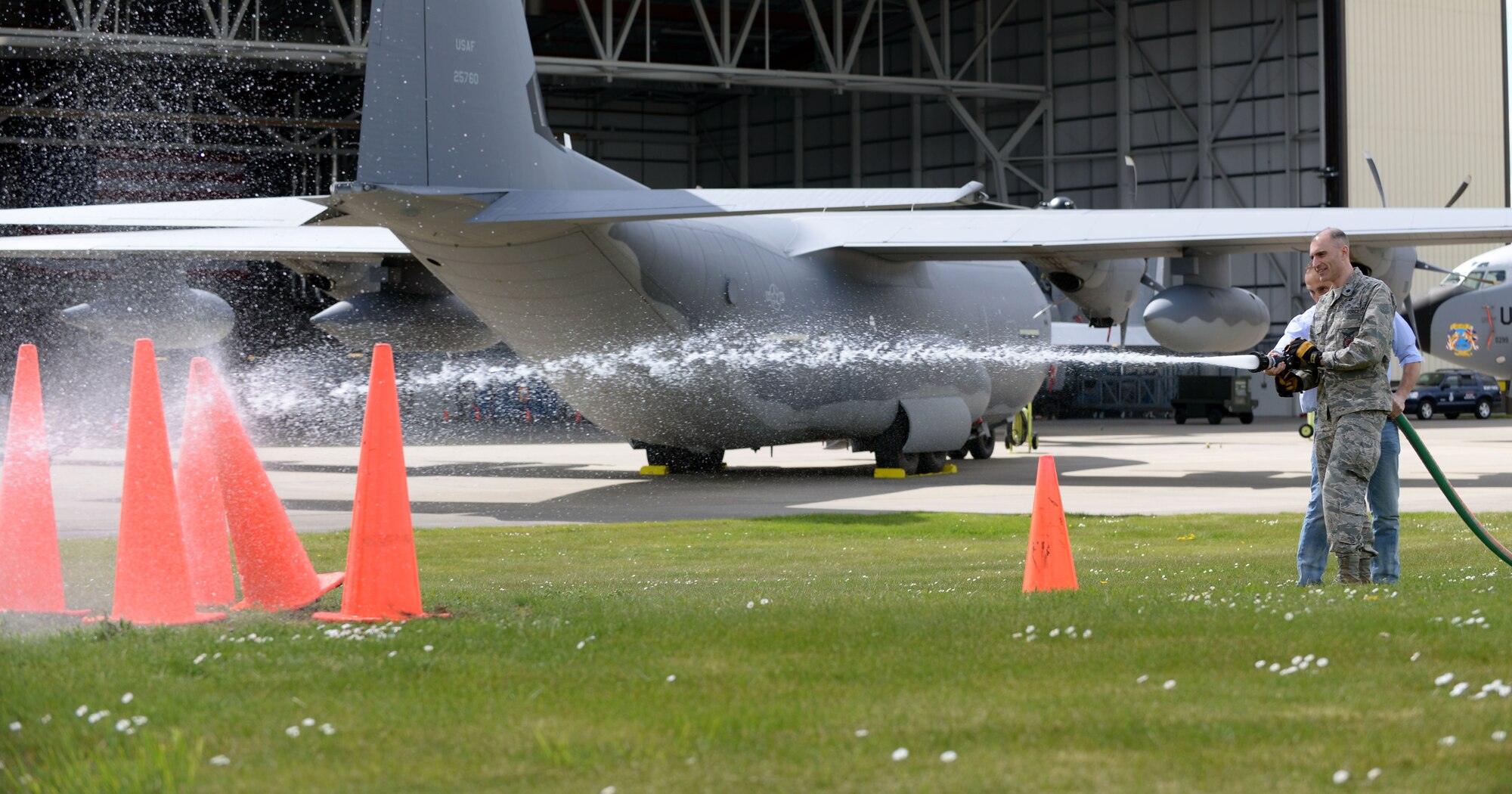 U.S. Air Force Lt. Col. Kevin Parker, 100th Civil Engineer Squadron commander, and John Illingworth, Suffolk Fire and Rescue Deputy District commander and the 100th CES honorary commander, knock down cones with a fire truck water hose April 28, 2015, during the Honorary Commander’s Day event on RAF Mildenhall, England. Honorary commanders visited the base to get a better understanding of RAF Mildenhall’s overall mission. (U.S. Air Force photo by Senior Airman Christine Halan/Released)