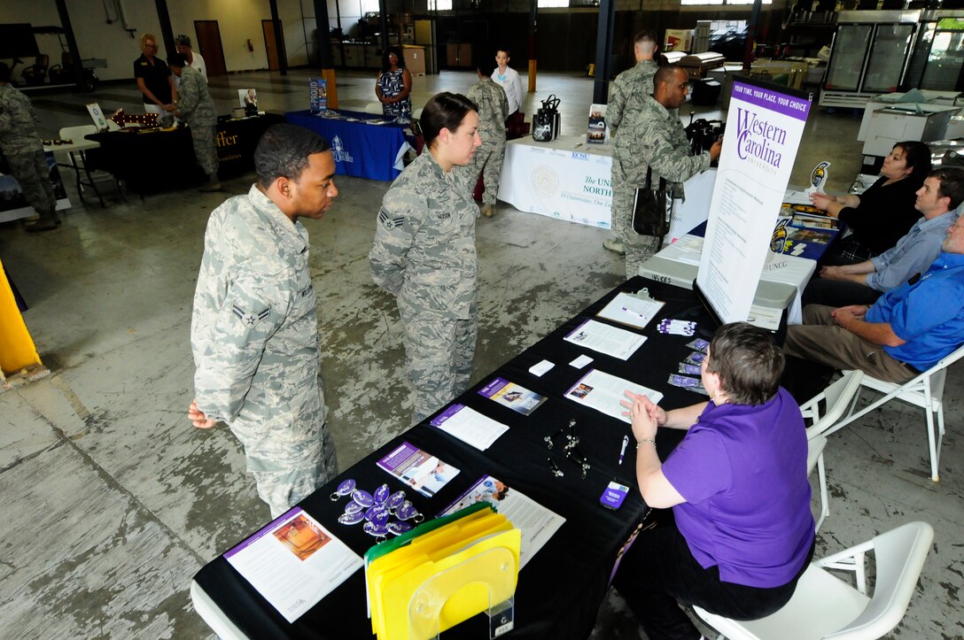 U.S. Air Force Airmen First Class Washington and Senior Airman Hixson, 145th Operations Support Squadron, get information from Briana Ford, a representative from Western Carolina University during the annual Educational Fair held at the North Carolina Air National Guard base, Charlotte Douglas Intl. Airport, April 18, 2015.  More than 45 airmen visited representatives from local and state colleges who came to showcase programs and benefits they offer to veterans. (U.S. Air National Guard photo by Master Sgt. Patricia F. Moran, 145th Public Affairs/Released)