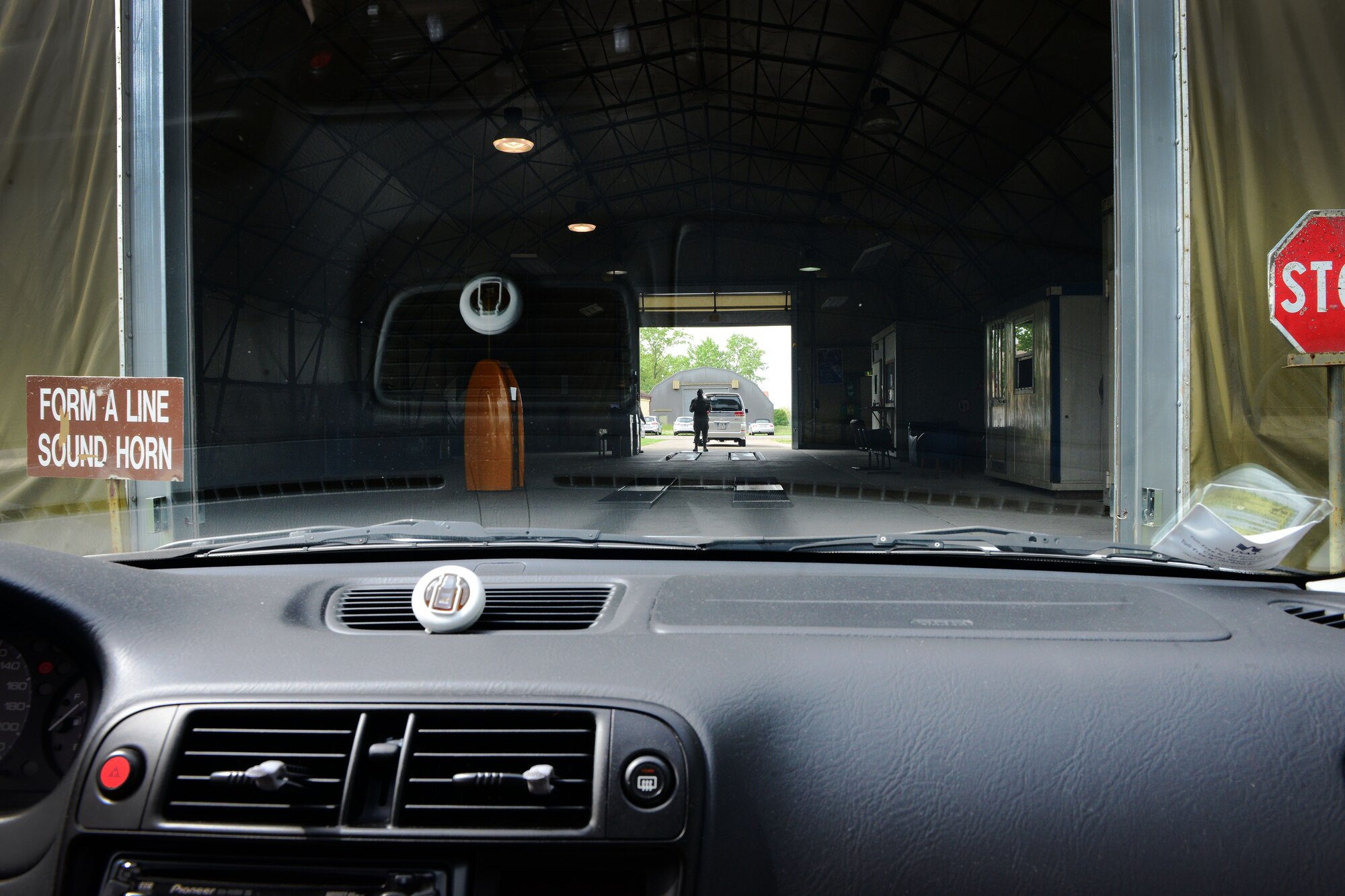 U.S. Air Force Senior Airman Jerald Foreman, 31st Logistics Readiness Squadron vehicle maintainer, guides a customer into the vehicle inspection tent, April 28, 2015, at Aviano Air Base, Italy. The 31 LRS vehicle inspectors are responsible for inspecting all privately owned vehicles to ensure their safety. These Airmen are responsible for checking vehicles’ brakes, tires and lights. (U.S. Air Force photo by Senior Airman Matthew Lotz/Released)