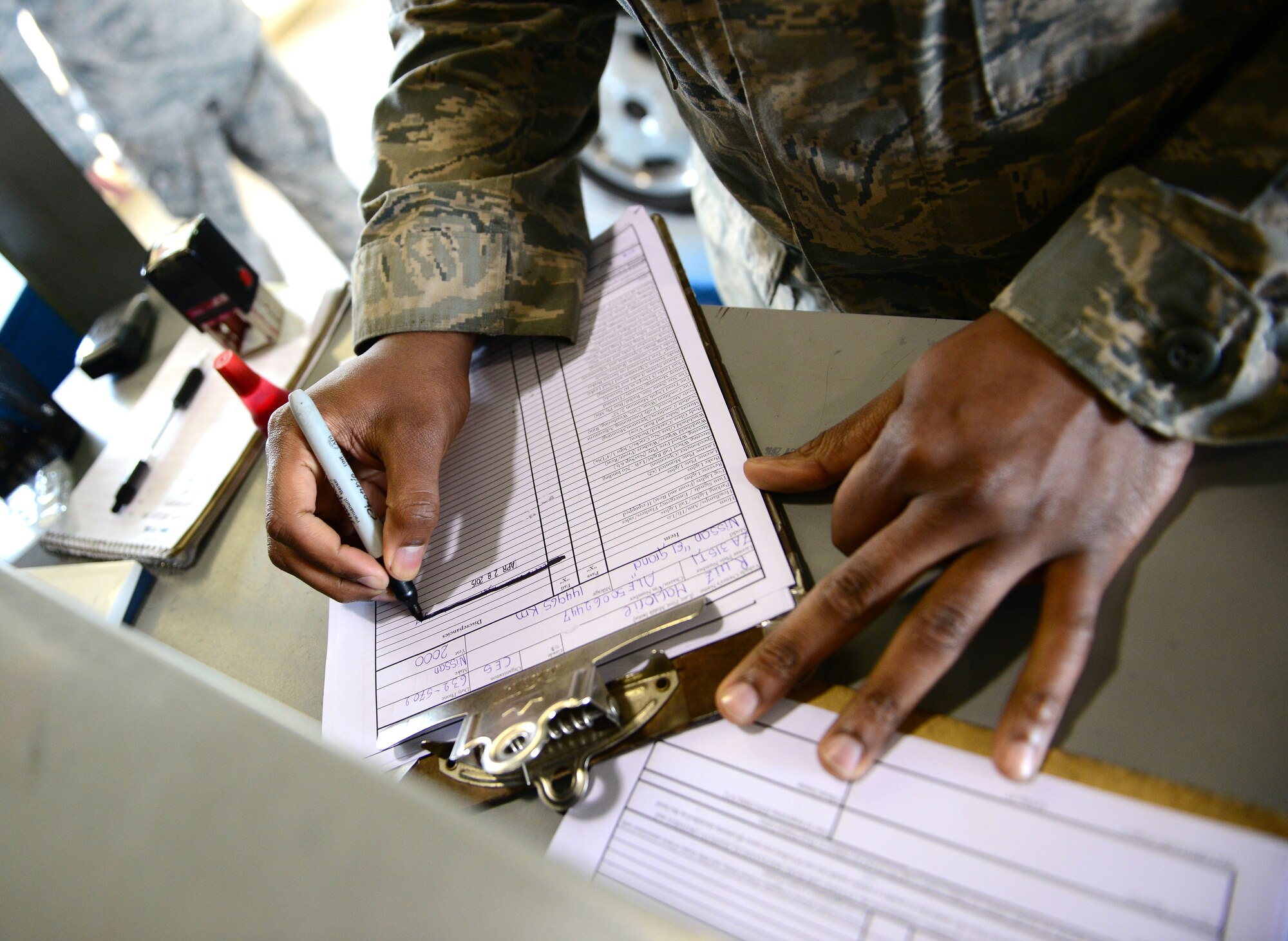 U.S. Air Force Senior Airman Jerald Foreman, 31st Logistics Readiness Squadron vehicle maintainer, completes an inspection form, April 28, 2015, at Aviano Air Base, Italy. Vehicle maintainers are responsible for checking vehicles’ brakes, tires and lights. The section inspected more than 5,000 privately owned vehicles last year.  (U.S. Air Force photo by Senior Airman Matthew Lotz/Released)