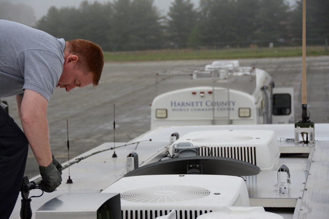 Mark Fow, Emergency Management contractor for the 145th Airlift Wing adjusts an antenna on the North Carolina Air National Guard, Mobile Emergency Operations Center (MEOC). NCANG partnered with more than twenty Emergency Management agencies, April 9, 2015, in Greensboro, N.C., to test communications during a natural disaster exercise and to showcase each agency’s capabilities. The MEOC provides the community’s incident commanders with emergency response support and interoperable communications. The MEOC responds to natural disasters, major accidents, incidents involving weapons of mass destruction and many other events. (U.S. Air National Guard photo by Senior Airman Laura Montgomery, 145th Public Affairs/Released)