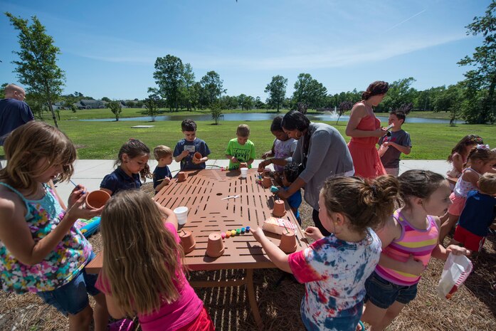 Children paint flower pots April 22, 2015, during the 45th annual Earth Day event at Joint Base Charleston, S.C. Forest City Military Communities invited base residents to attend the environmental celebration which included activities for children and a yard care lesson from a local landscaping company. Participants were given grass seed to encourage growing a healthy yard. (U.S. Air Force photo/Senior Airman Jared Trimarchi) 