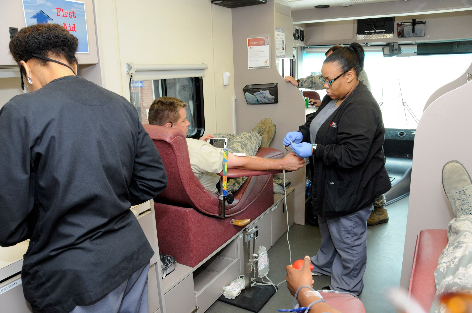 A nurse from Community Blood Center of the Carolinas secures a tube with surgical tape as 
U. S. Air Force Master Sgt. Todd Latour, 145th Civil Engineer Squadron, waits to donate blood during a blood drive held at the North Carolina Air National Guard base, Charlotte Douglas Intl. Airport, April 18, 2015. The blood donated by airmen at CBCC stays in the community helping patients in local hospitals. Roughly one pint is given during a donation. Each donation can help save up to three lives (U.S. Air National Guard photo by Master Sgt. Patricia F. Moran, 145th Public Affairs/Released)
