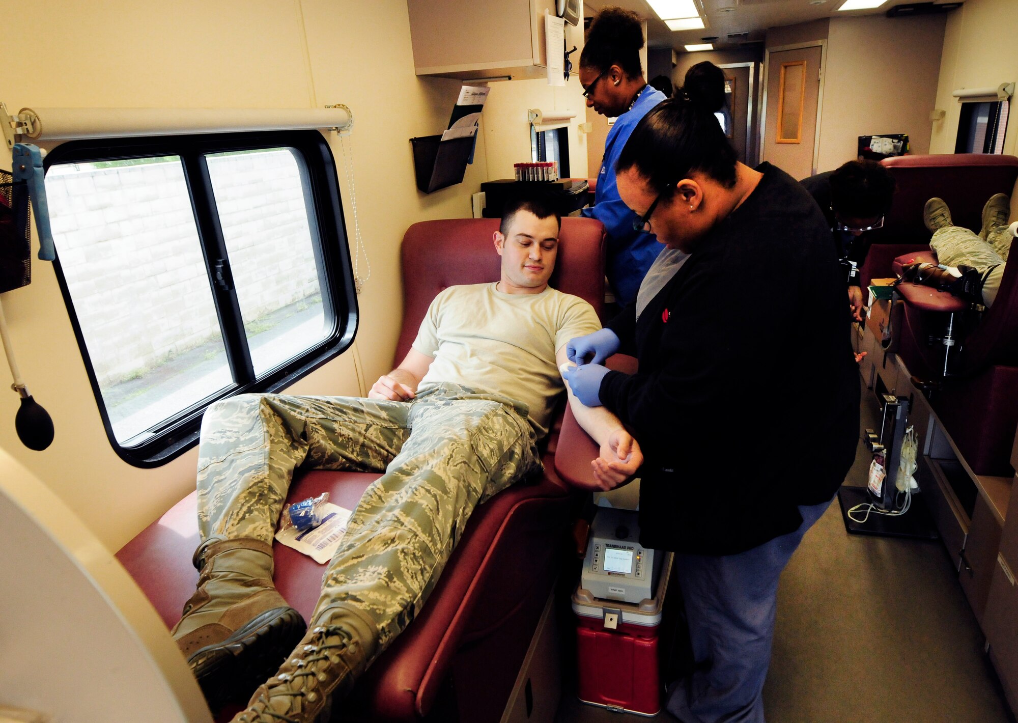 U. S. Air Force Staff Sgt. Bradley Hinote, 145th Communications Flight, donates blood inside the Community Blood Center of the Carolinas mobile unit, during a blood drive held at the North Carolina Air National Guard base, Charlotte Douglas Intl. Airport, April 18, 2015. The blood donated by airmen at CBCC stays in the community helping patients in local hospitals. (U.S. Air National Guard photo by Master Sgt. Patricia F. Moran, 145th Public Affairs/Released)