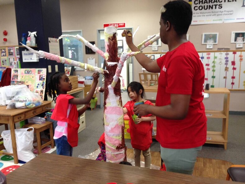 Winners of the unit group division of the Earth Day Recycled Art Contest, the Student Age Program, prepare their entry for the contest. The entry, called Sakura, was constructed from a number of recycled materials including plastic bottles and a Christmas tree stand. (Courtesy photo)