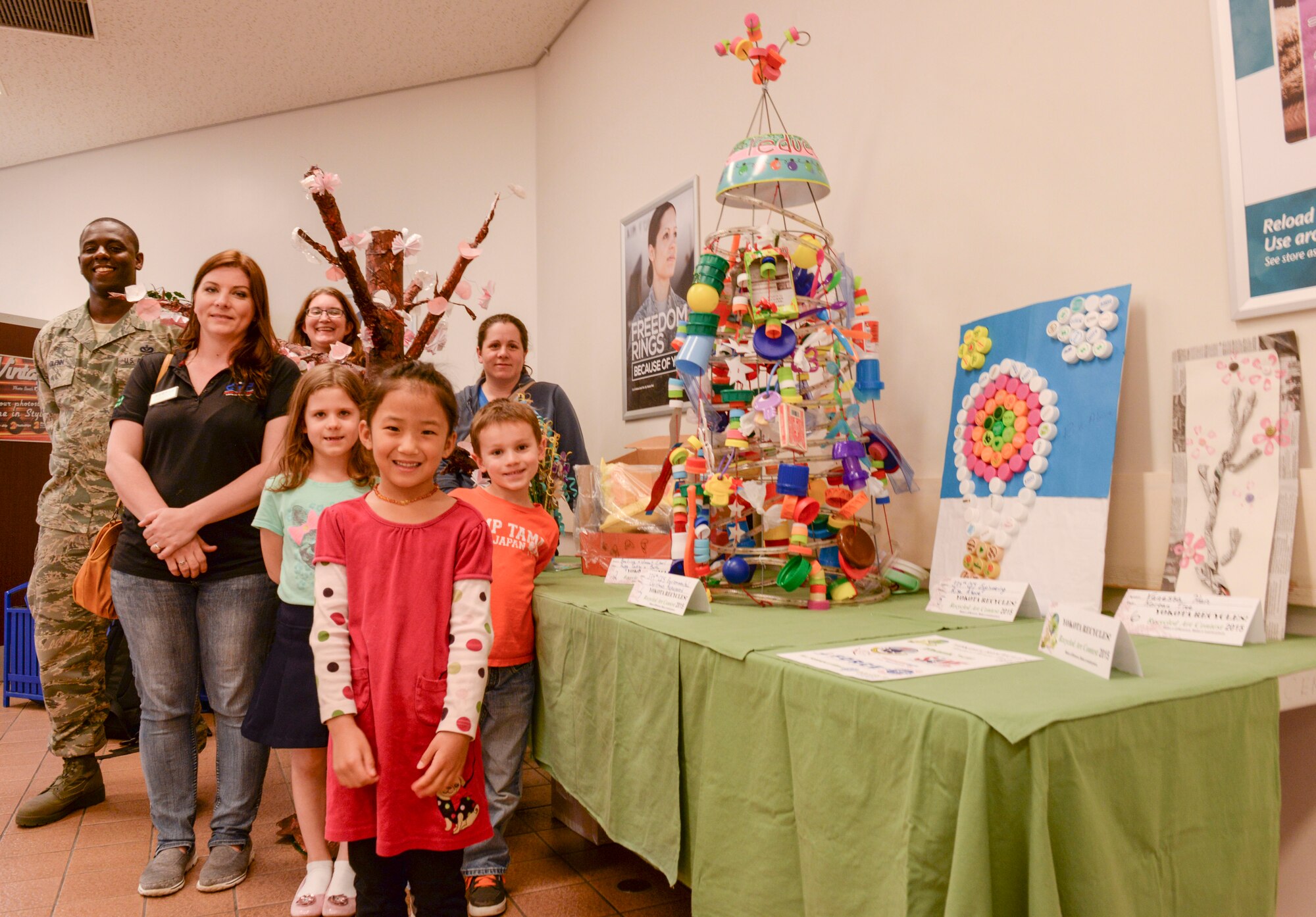 Artists and organisers of the Recycled Art contest pose alongside the contest entries April 22, 2015, at Yokota Air Base, Japan. After 654 votes were tallied, winners were selected from three divisions: class or unit group, grade K-5 and adult. (U.S. Air Force photo by Airman 1st Class Elizabeth Baker/Released)
