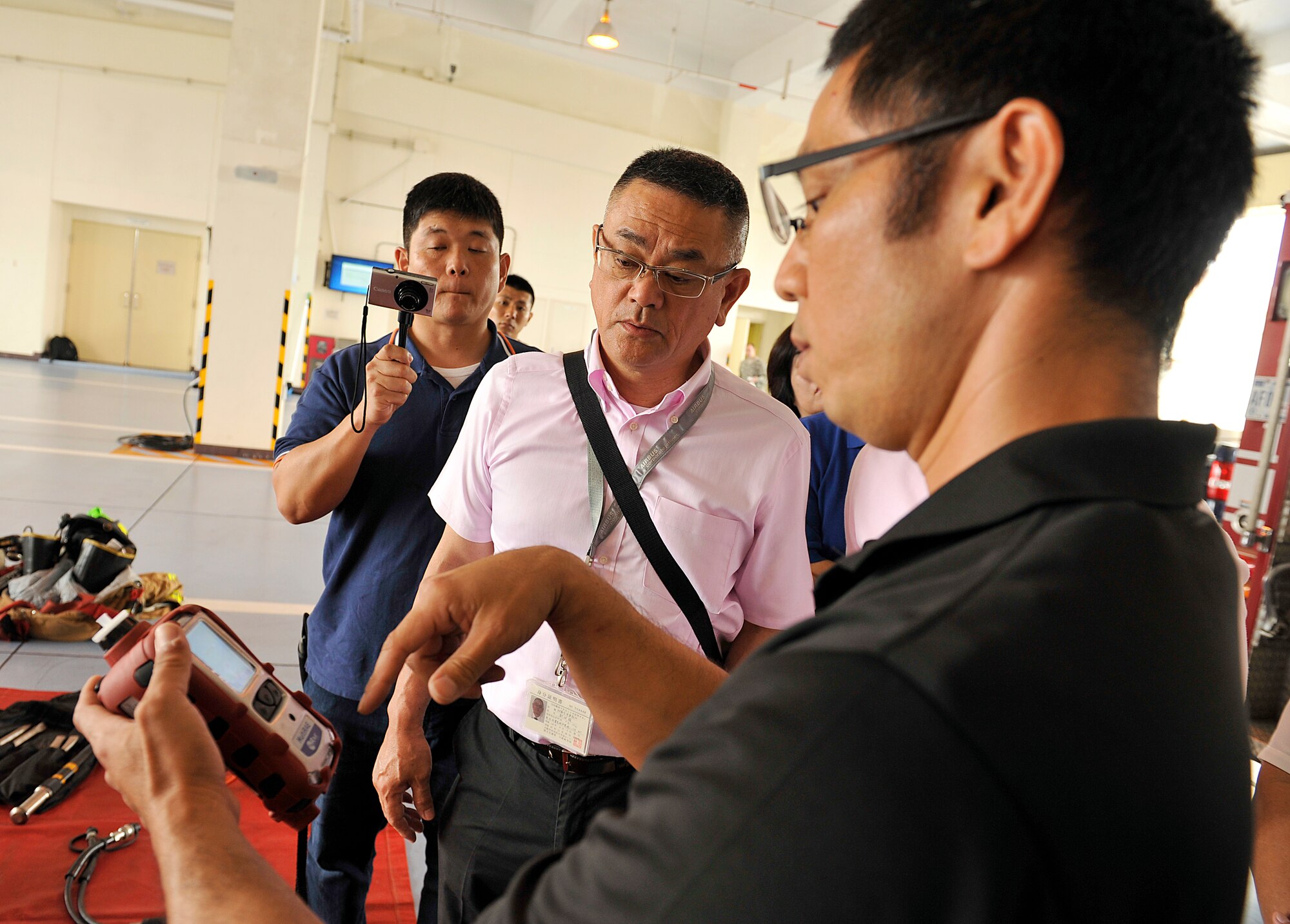 Ryosaku Higa, 18th Civil Engineer Squadron firefighter explains how to use a gas detector during a visit from the Civil Aviation Bureau, Naha Airport, to Kadena Air Base, Japan, April 29, 2015. Eight members from the bureau received a brief of Kadena's fire emergency service capabilities and learned about aircraft firefighting techniques. (U.S. Air Force photo by Naoto Anazawa)