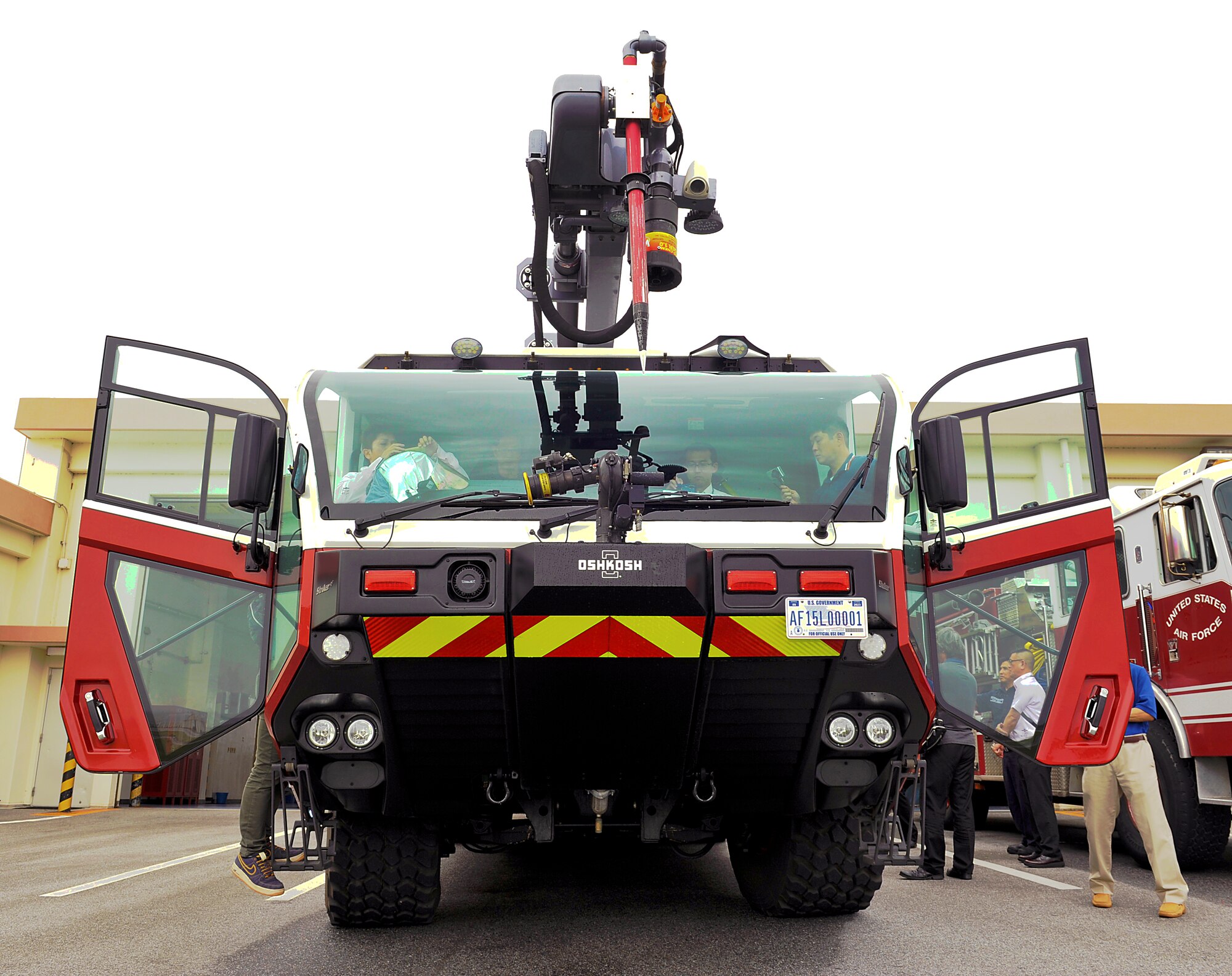 Members from Civil Aviation Bureau, Naha Airport, get inside of an Oshkosh striker to take photos during their visit to Kadena Air Base, Japan, April 29, 2015. Eight crews from the Civil Aviation Bureau, Naha Airport, visited Kadena to observe how Kadena educates firefighters annually and what type of equipment they use for emergency response. (U.S. Air Force photo by Naoto Anazawa)