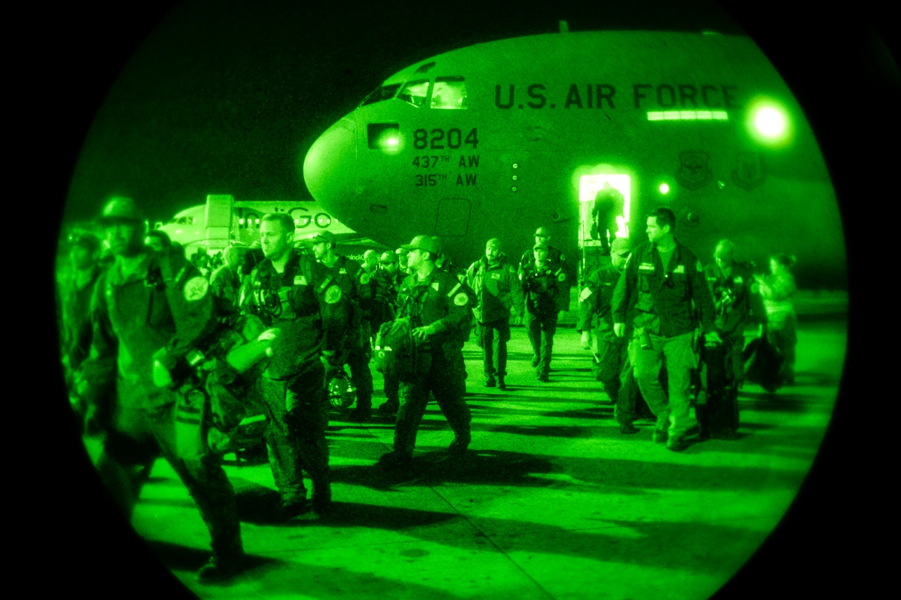 Members of U.S. Agency for International Development and Los Angeles County search-and-rescue teams depart from a U.S. Air Force C-17 transport jet in Kathmandu, Nepal, April 28, 2015. The Air Force transported personnel, supplies and search-and-rescue dogs to help victims of a magnitude-7.8 earthquake. U.S. Air Force photo by Airman 1st Class Taylor Queen