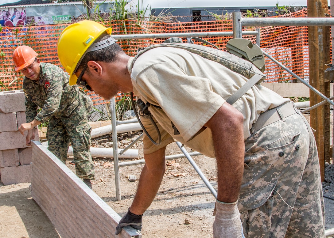 U.S. Army Spc. William Epps works with a Salvadoran soldier to set up ...