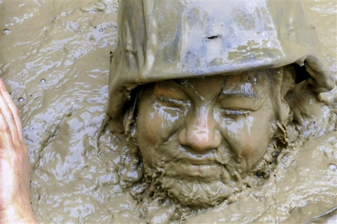 U.S. Navy Seaman April Schwertman emerges from muddy water at the Jungle Warfare Training Center's "pit and pond" in Okinawa, Japan, April 24, 2015. More than 60 Seabees attended the weeklong course, which prepares Marines and joint forces for combat in a dense jungle environment. Schwertman is assigned to Naval Mobil Construction Battalion 5, which serves several countries in the Pacific area of operations. 
