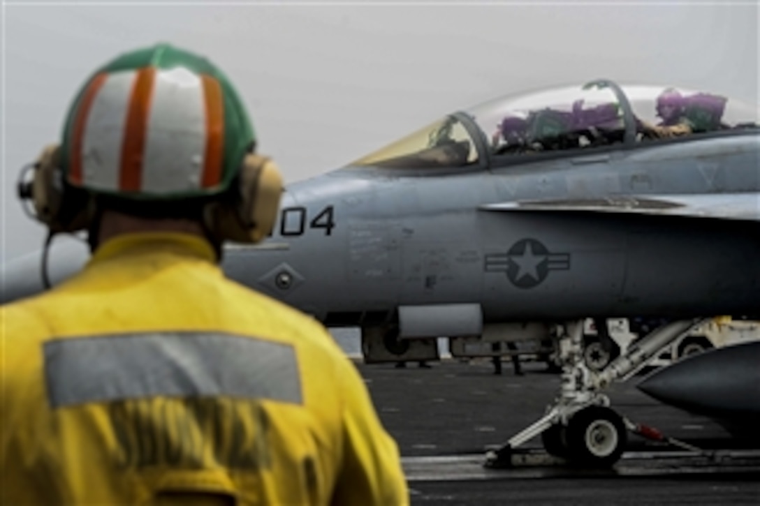 U.S. Navy Cmdr. Joshua Sager salutes from the cockpit of an F/A-18F Super Hornet aircraft before taking off from the flight deck of the aircraft carrier USS Theodore Roosevelt in the U.S. 5th Fleet area of responsibility, April 28, 2015. Sager is the outgoing commanding officer of Strike Fighter Squadron 11.