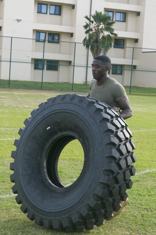 Sgt. David Williams flips a tire for 100 yards as part of the 400-yard tactical course event of High Intensity Tactical Training Tactical Athlete Competition held at Riseley Field, July 29, 2015. Williams, of Indianapolis, is a noncommissioned officer in charge of the administration section at Headquarters and Service Battalion at Camp H.M. Smith. The match was officiated by Marine Corps Community Services staff at the Semper Fit Center. The mission of MCCS is to contribute to the readiness and retention of Marines, Sailors, and family members aboard Marine Corps Base Hawaii by providing fitness and recreation programs, Marine and family programs, and business activities in garrison and deployed environments. (U.S. Marine Corps photo by Christine Cabalo/Released)