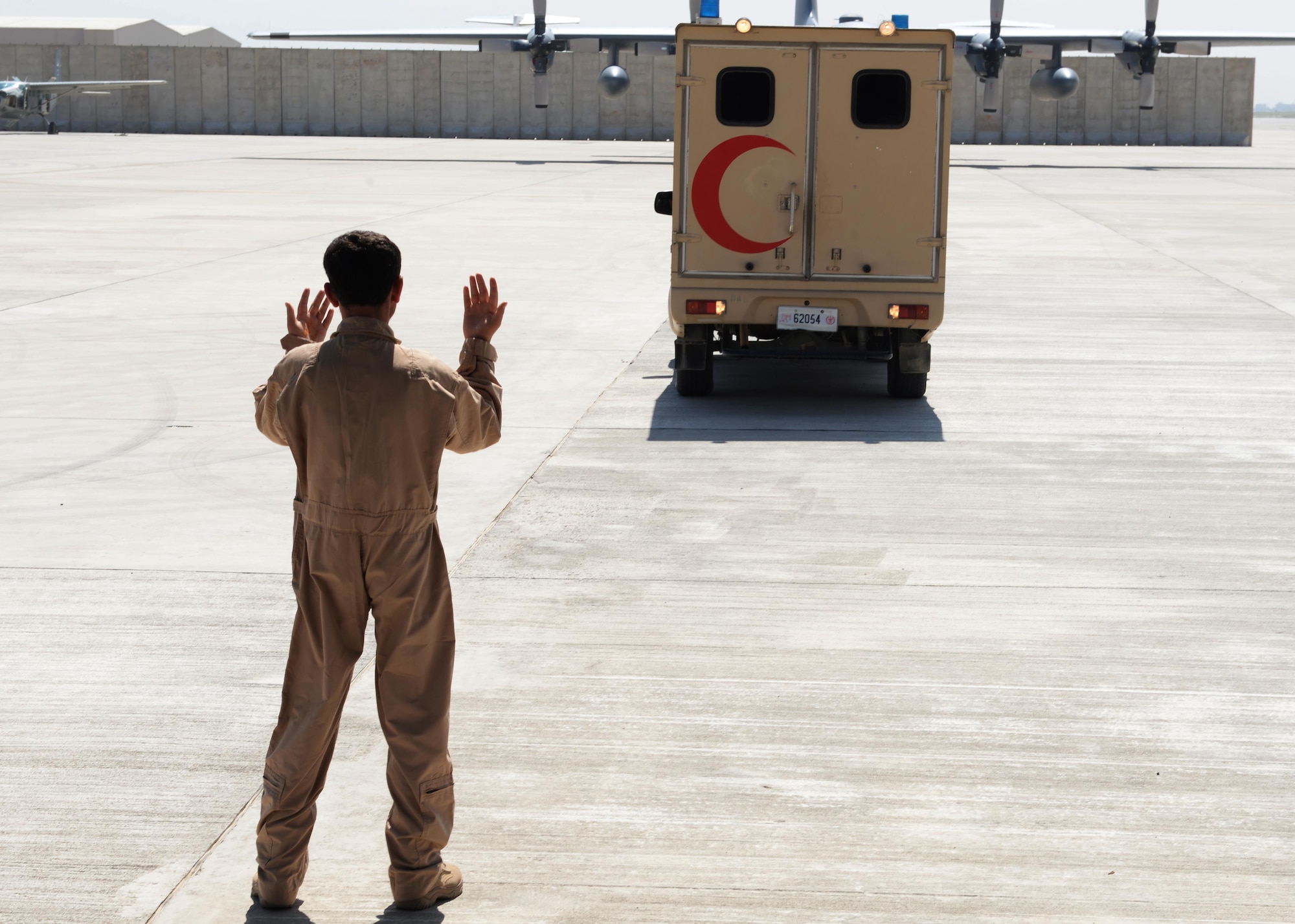 A member of the Afghan National Army medical evacuation team directs an ambulance during medevac training July 29, 2015, at Hamid Karzai International Airport, Kabul, Afghanistan. The Train, Advise, Assist Command-Air advisors host weekly training with the Afghan flight medics with assistance from U.S. Air Force aeromedical evacuation subject matter experts. (U.S. Air Force photo by Senior Airman Cierra Presentado/Released)