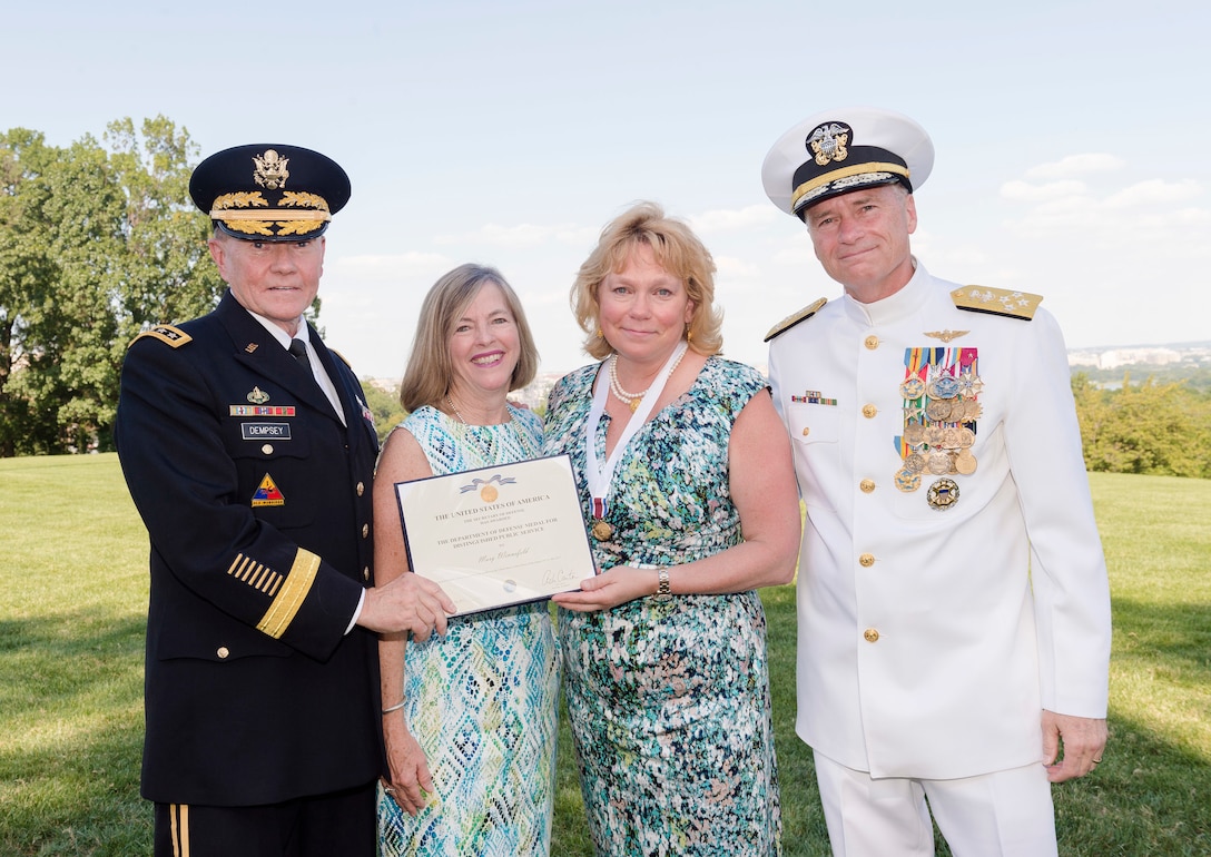 From left, Army Gen. Martin E. Dempsey, chairman of the Joint Chiefs of Staff, and his wife, Deanie, present a Department of Defense Medal for Distinguished Public Service to Mary Winnefeld, wife of Navy Adm. James A. Winnefeld Jr., vice chairman of the Joint Chiefs of Staff, on Joint Base Myer-Henderson Hall, Va., July 31, 2015, during a retirement ceremony for the admiral.