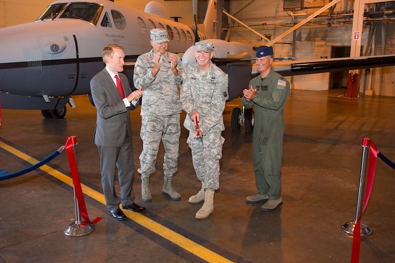 Oklahoma Army and Air National Guard Adjutant General Maj. Gen. Robbie L. Asher cuts a ribbon during a ceremony Saturday, Aug. 1, 2015 at Will Rogers Air National Guard Base, Okla. Asher was accompanied by (Left to right) Oklahoma Sen. James Lankford, Air Force Special Operations Command Commander Lt. Gen. Bradley A. Heithold and 137th Air Refueling Wing Commander Col. Devin Wooden. The 137 ARW celebrated the arrival of the MC-12W and the transition into the AFSOC. (U.S. Air National Guard photo by Tech. Sgt. Caroline Essex/ Released)  