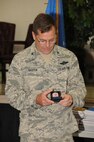 Col.William Griffin, 111th Attack Wing vice commander, looks at the coins being given to 111 ATKW members who recently re-enlisted, Aug. 1, 2015, Horsham Air Guard Station, Pennsylvania. The coins, along with other items, were formally presented by the 111th ATKW Strength Management Team during the commander's call of this month's unit training assembly. (U.S. Air National Guard photo by Tech. Sgt. Andria Allmond/Released)