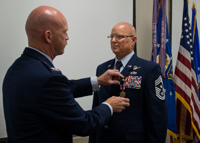 Chief Master Sgt. Tom Mason, the 919th Special Operations Wing command chief, receives a meritorious service medal during his retirement ceremony Aug. 1 at Duke Field, Fla. Surrounded by friends and family, Mason said goodbye to the 919th Special Operations Wing and the Air Force after 33 years of service. (U.S. Air Force photo/Tech. Sgt. Jasmin Taylor)