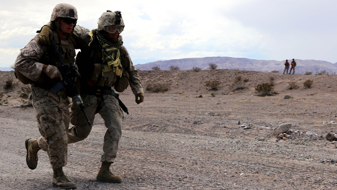 A Marine with Truck Company, 3rd Marine Division, III Marine Expeditionary Force, assists a fellow Marine to an aircraft to be evacuated for notional injuries suffered from a simulated improvised explosive device during a motorized operations course aboard Marine Corps Air Ground Combat Center Twentynine Palms, Calif., July 30. The Marines were evaluated on their performance to determine whether their standard operating procedures were effective or ineffective.