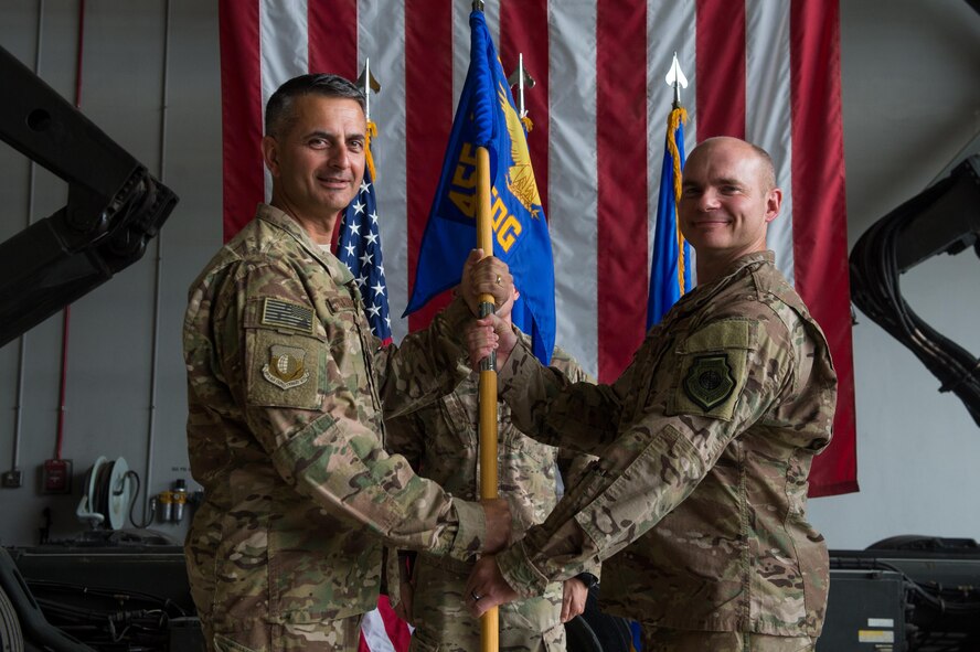 U.S. Air Force Brig. Gen. Dave Julazadeh, 455th Air Expeditionary Wing commander, hands the guidon to Col. Henry Rogers, 455th Expeditionary Operations Group incoming commander, during the 455th EOG change of command ceremony at Bagram Airfield, Afghanistan, Aug. 3, 2015. The 455th EOG is responsible for all expeditionary flying and aeromedical evacuation operations for the 455th AEW. (U.S. Air Force photo by Tech. Sgt. Joseph Swafford/Released)