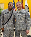 Army Spc. Andrew Deason, an Iraqi security forces knowledge management representative assigned to the 36th Infantry Division, Texas Army National Guard, poses for a photo with Sergeant Major of the Army Raymond F. Chandler III during his visit to Contingency Operating Base Basra, Iraq June 25, 2011. Deason competes with his brother, Spc. Brian Brown, who is currently an active duty member in the Army, to see which of them can meet the highest-ranking military officials. The brothers have an ongoing competition that began when Deason joined the Guard two years after Brown joined the Army.