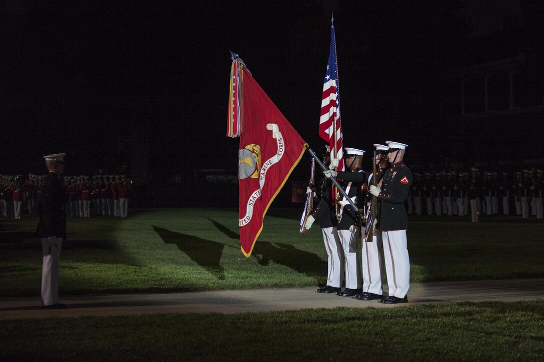 U.S. Marines with Marine Barracks Washington, D.C., color guard present colors during an evening parade, July 31, 2015. U.S. Army Gen. Martin E. Dempsey, Chairman, Joint Chiefs of Staff, was the guest of honor for the parade at Marine Barracks Washington, D.C., and Gen. Joseph F. Dunford, 36th commandant of the Marine Corps, was the hosting official for that same parade.  The Evening Parade summer tradition began in 1934 and features the Silent Drill Platoon, the U.S. Marine Band, the U.S. Marine Drum and Bugle Corps and two marching companies. More than 3,500 guests attend the parade every week. (U.S. Marine Corps photo by Lance Cpl. Samantha K. Draughon/Released)
